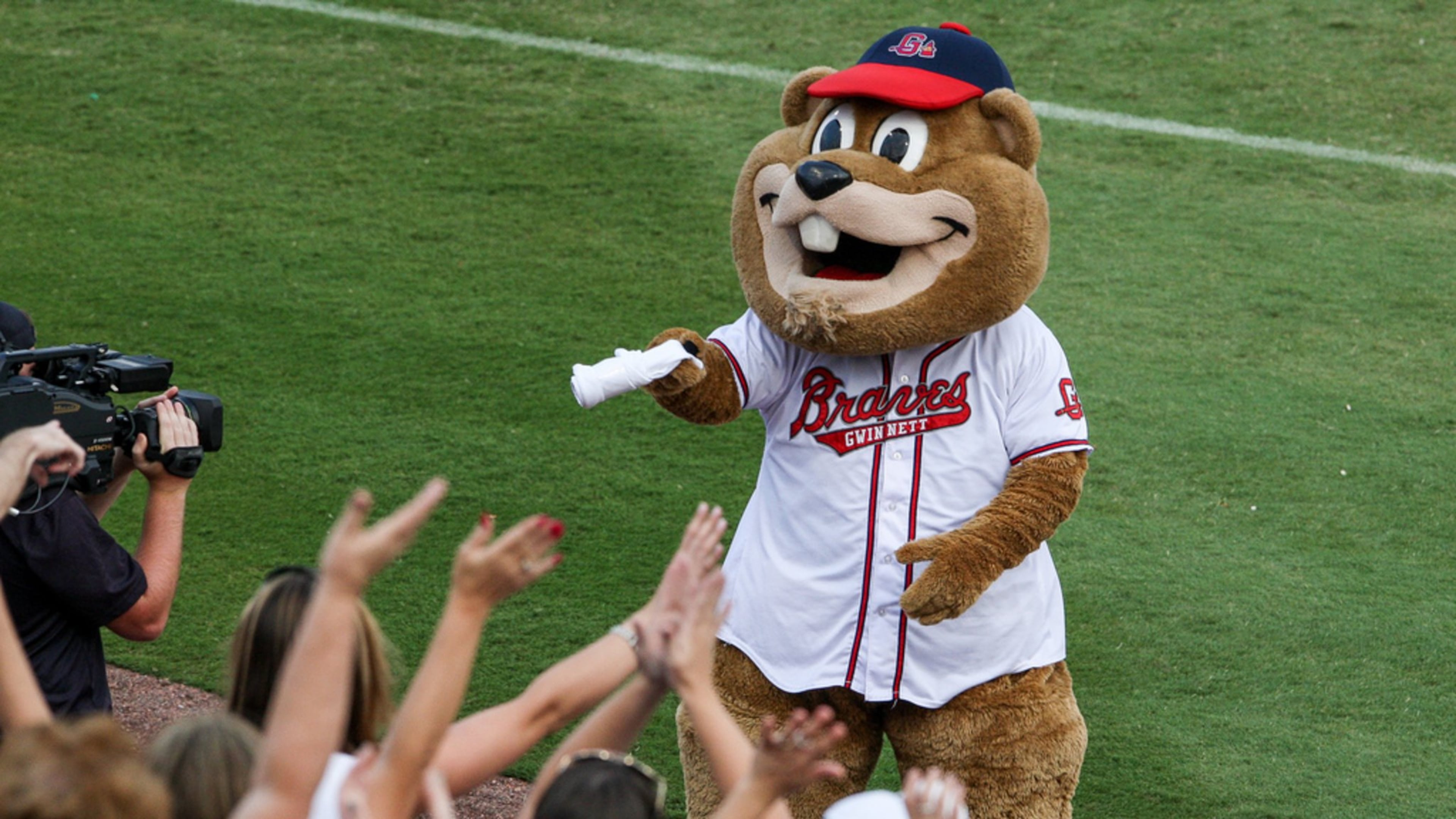 Chopper, the groundhog mascot of the Gwinnett Braves, hands out T-shirts to fans at a game. Credit: Karl Moore/Gwinnett Braves.