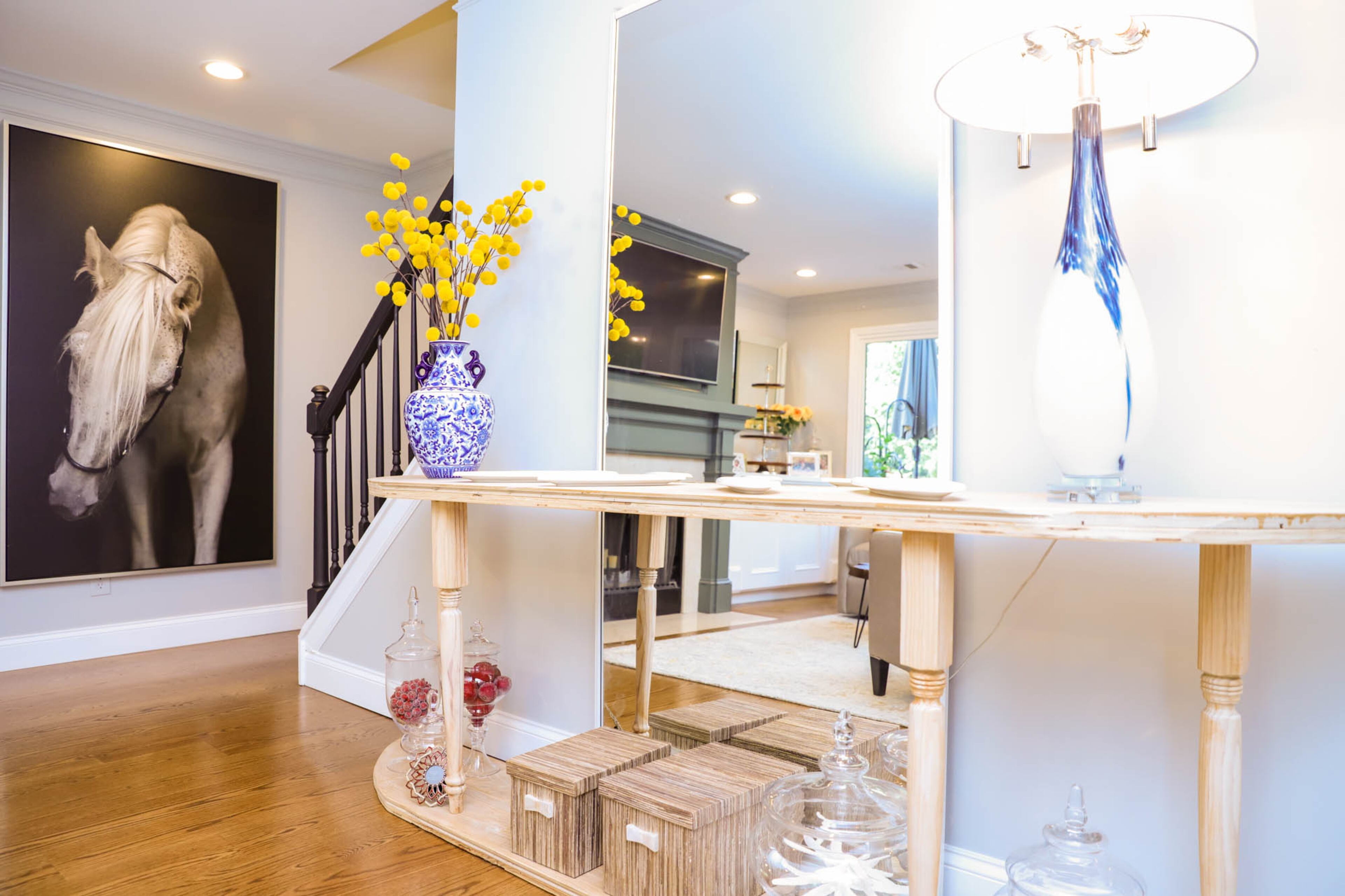 A stunning piece of art from Haverty’s depicting a white horse on a black background is one of Liza Hare’s favorite pieces in her living room. Along the wall by the stairs is a console table that she built herself, creating the sleek, open piece of furniture when she had trouble finding what she wanted. Text by Shannon Dominy/Photo by Reynolds Rogers