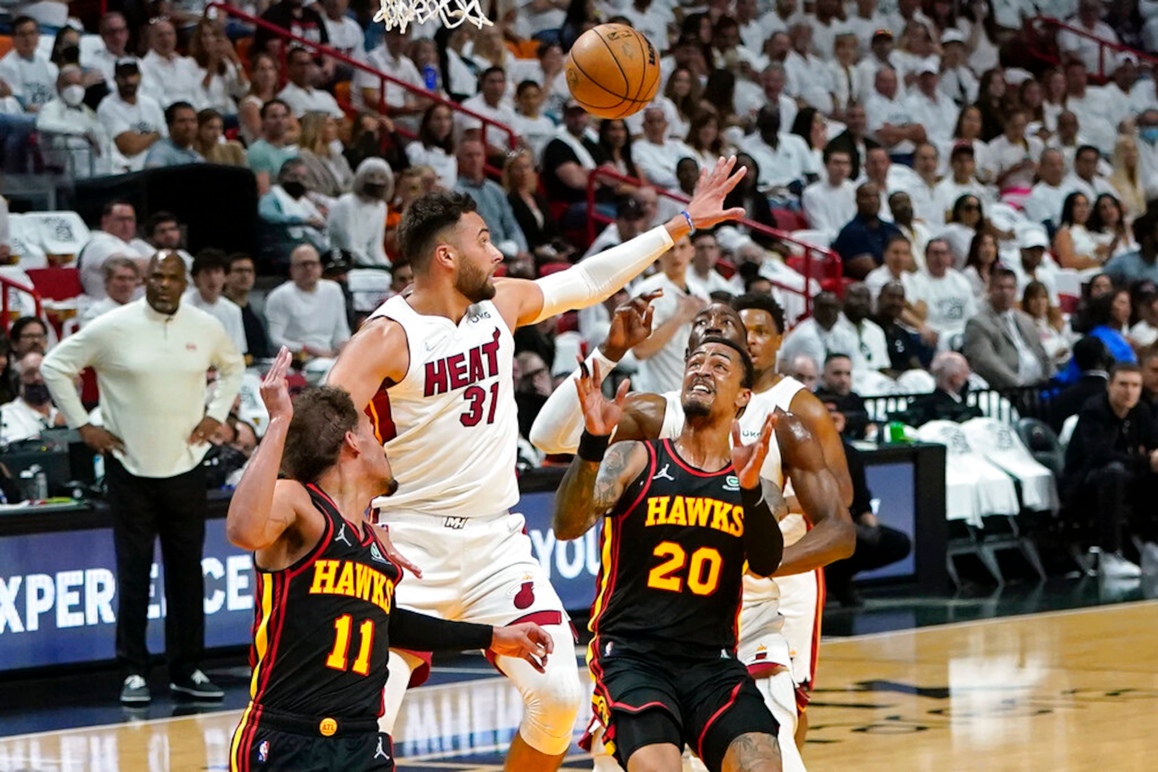 Miami Heat guard Max Strus (31) defends as Atlanta Hawks forward John Collins (20) passes the ball during the first half of Game 2 of an NBA basketball first-round playoff series, Tuesday, April 19, 2022, in Miami. At left is Atlanta Hawks guard Trae Young (11) (AP Photo/Lynne Sladky)
