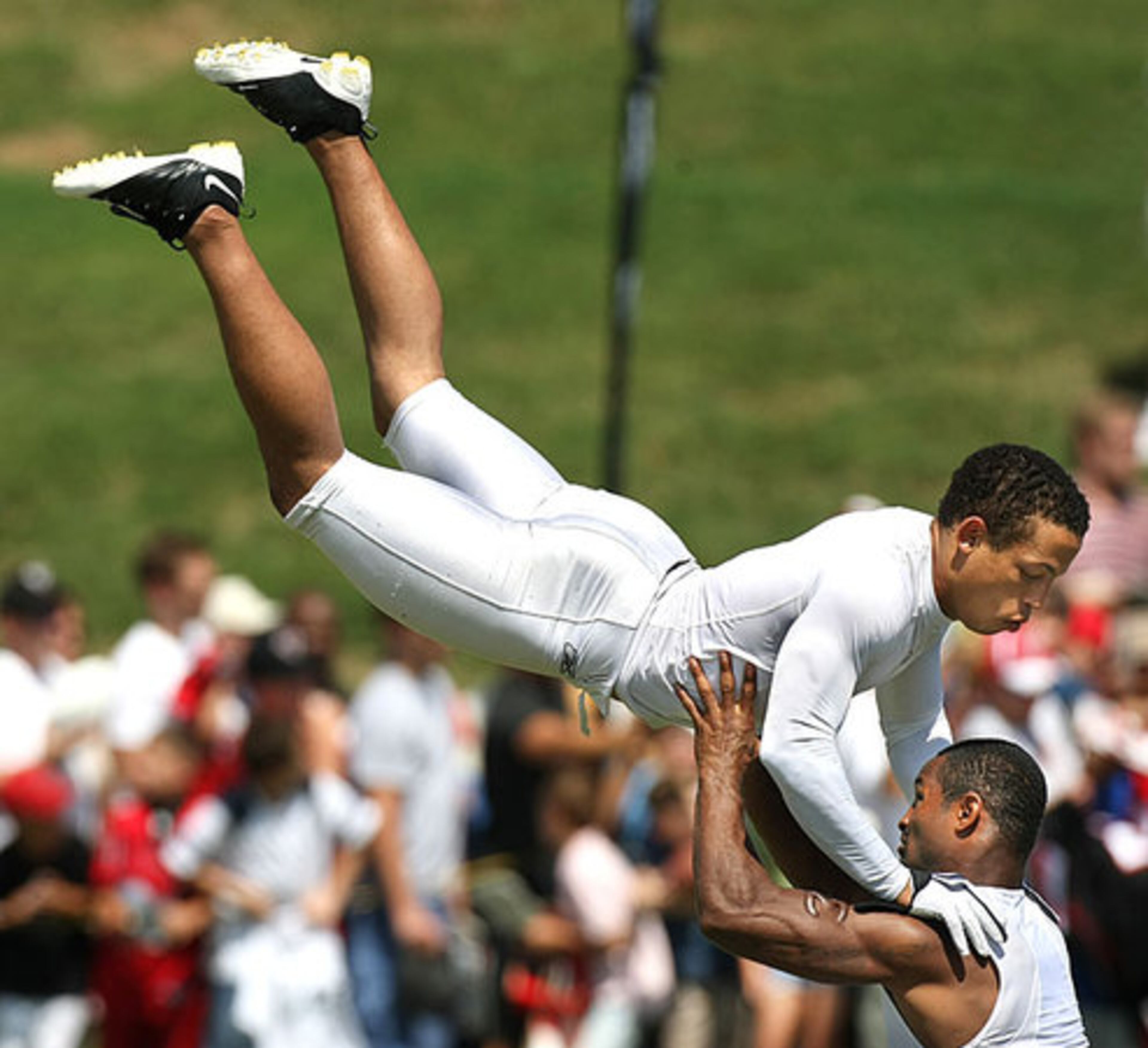 Falcons cornerback Brent Grimes (left) gets some air as he is hoisted by fellow cornerback Christopher Owens (right) during a drill.