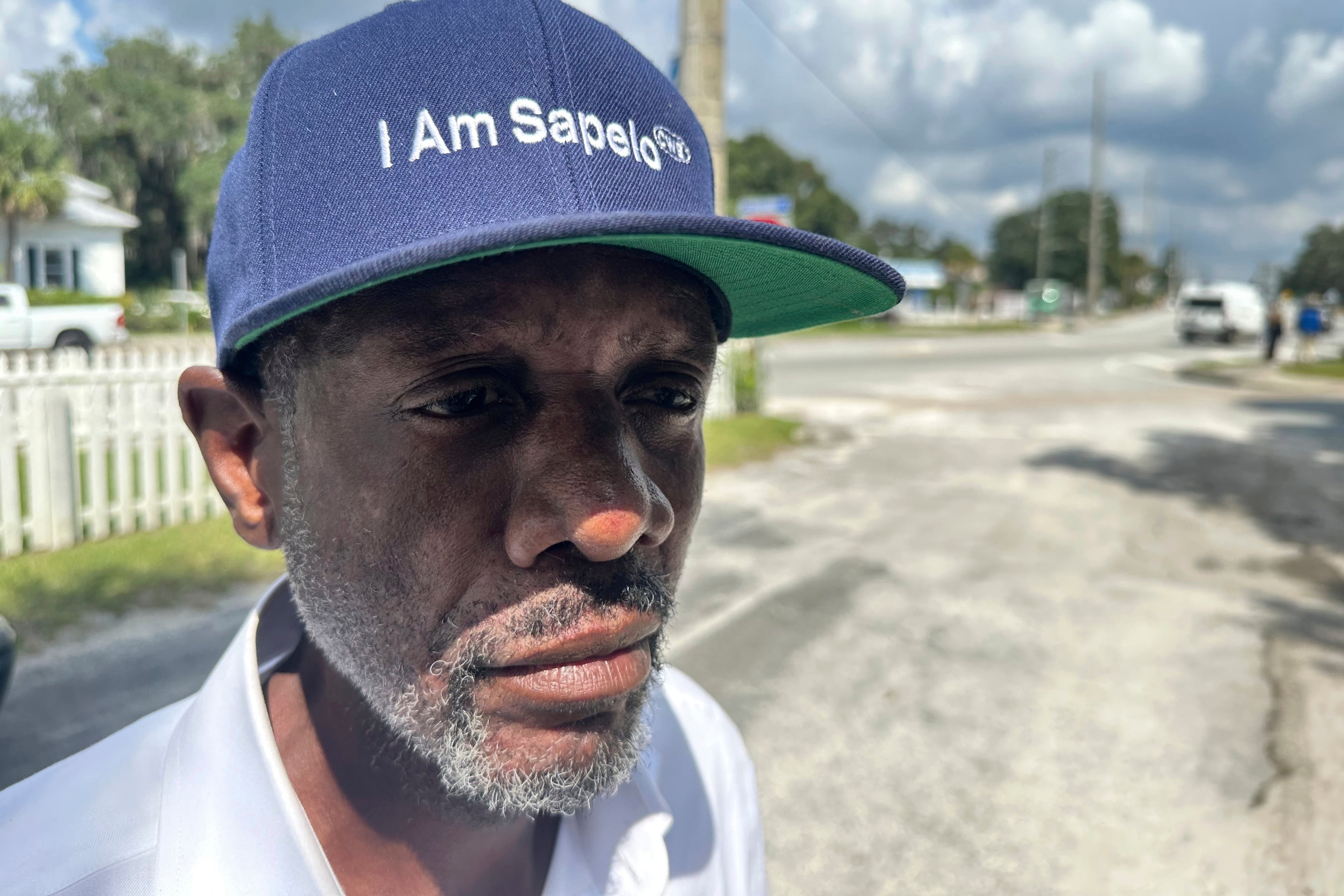 Jazz Watts, a resident of Sapelo Island, wears a hat that reads "I am Sapelo" outside the McIntosh County courthouse in Darien. (Russ Bynum/AP 2024)