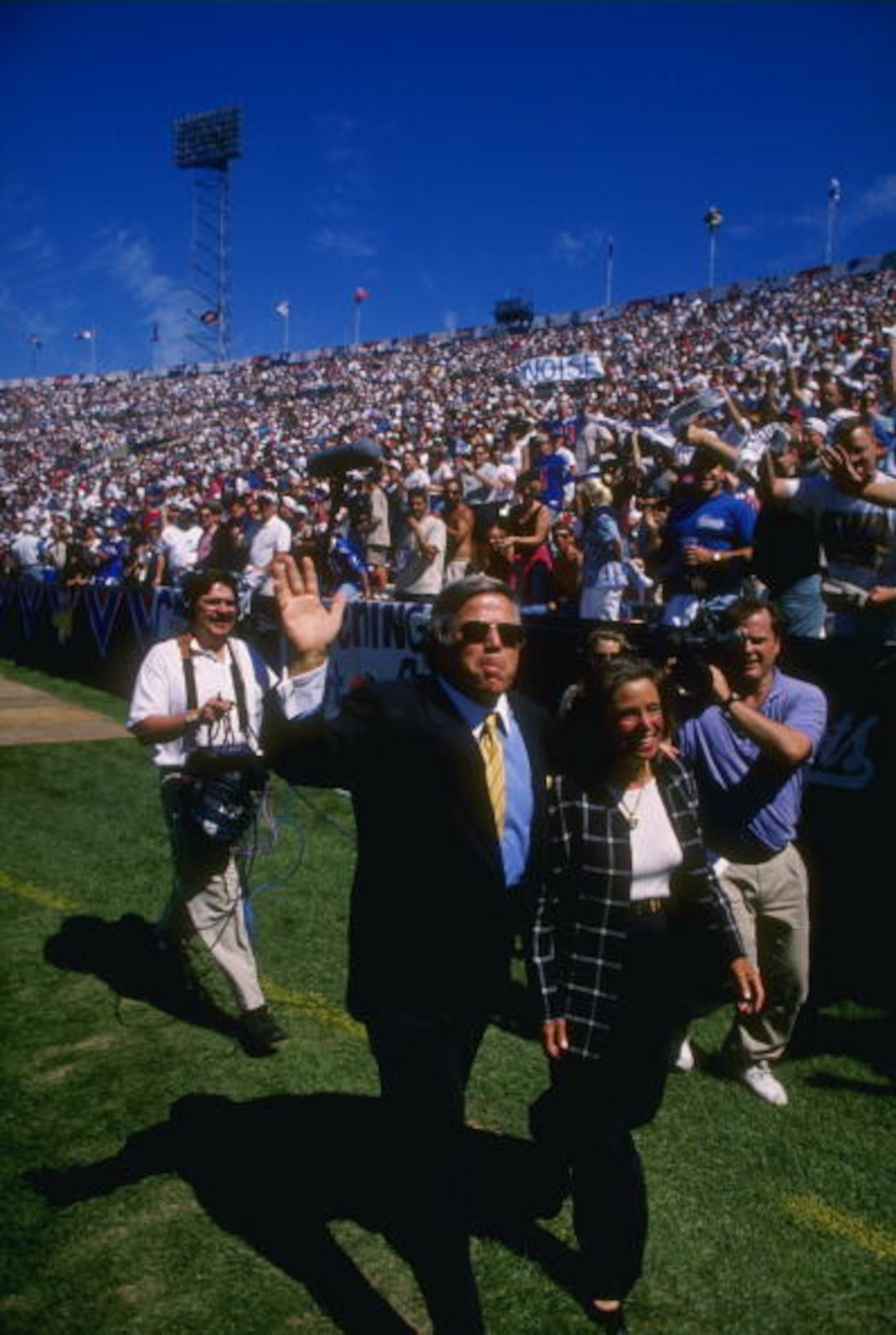 2 Sep 1995: Owner Robert Kraft of the New England Patriots and his wife wave to the crowd as they are acknowledged by the public address announcer during pre game warm ups before the Patriots 17-14 victory over the Cleveland Browns at Foxboro Stadium in