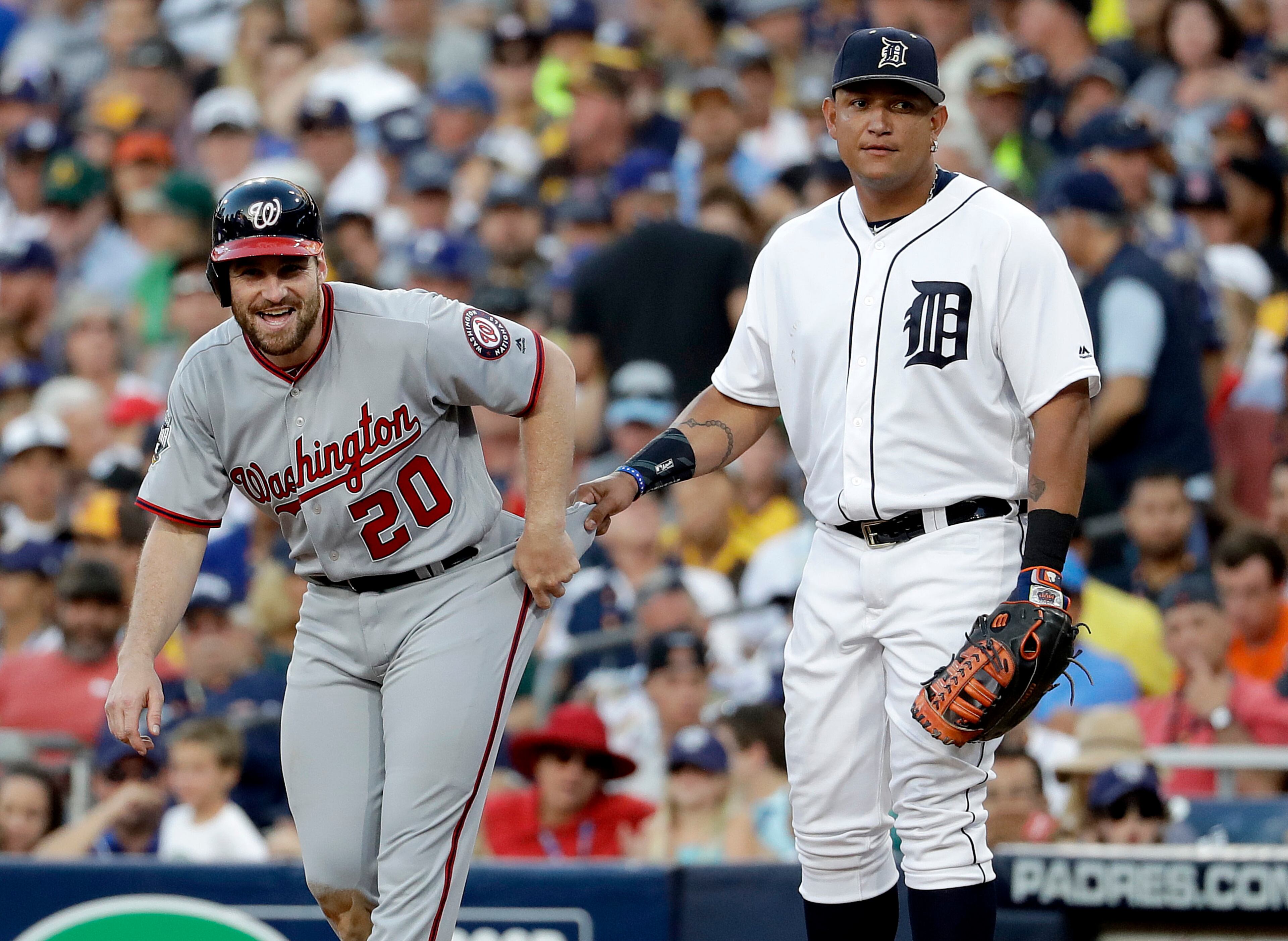 American League's Miguel Cabrera, of the Detroit Tigers, right, holds the pants of National League's Daniel Murphy, of the Washington Nationals, as he takes a lead during the seventh inning of the MLB baseball All-Star Game, Tuesday, July 12, 2016, in San Diego. (AP Photo/Gregory Bull)