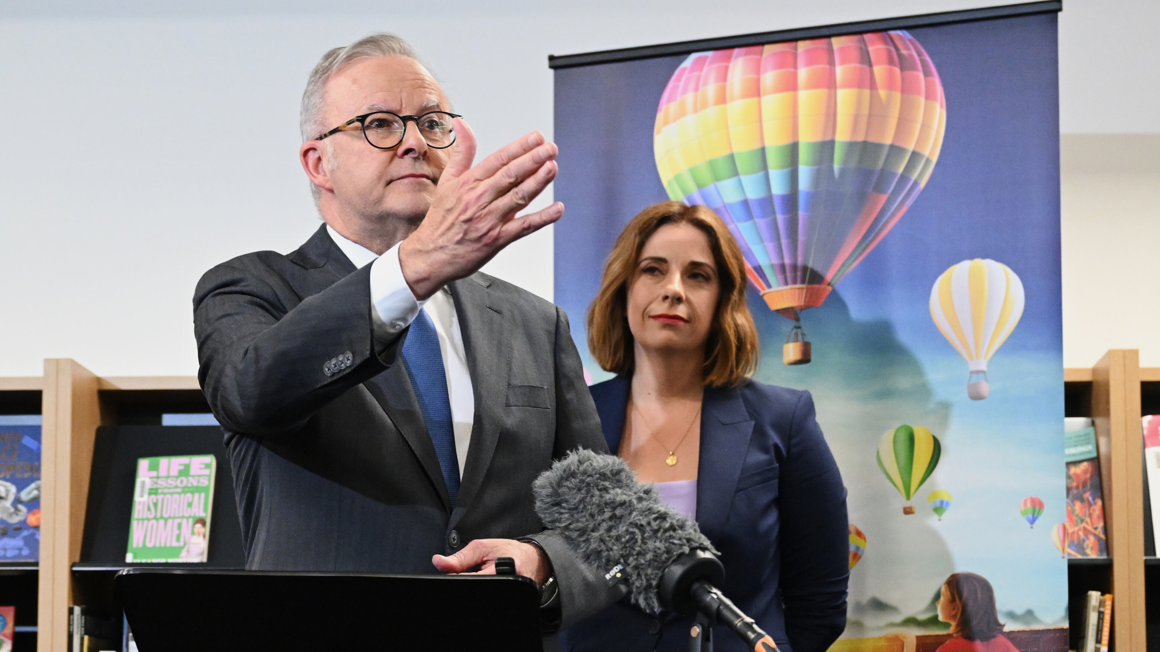 Australian Prime Minister Anthony Albanese, left, and Australian Communications Minister Anika Wells speak to the media during a visit to St John Paul II College in Canberra, Australia, on Dec. 11, 2025. (Lukas Coch/AAP Image via AP)