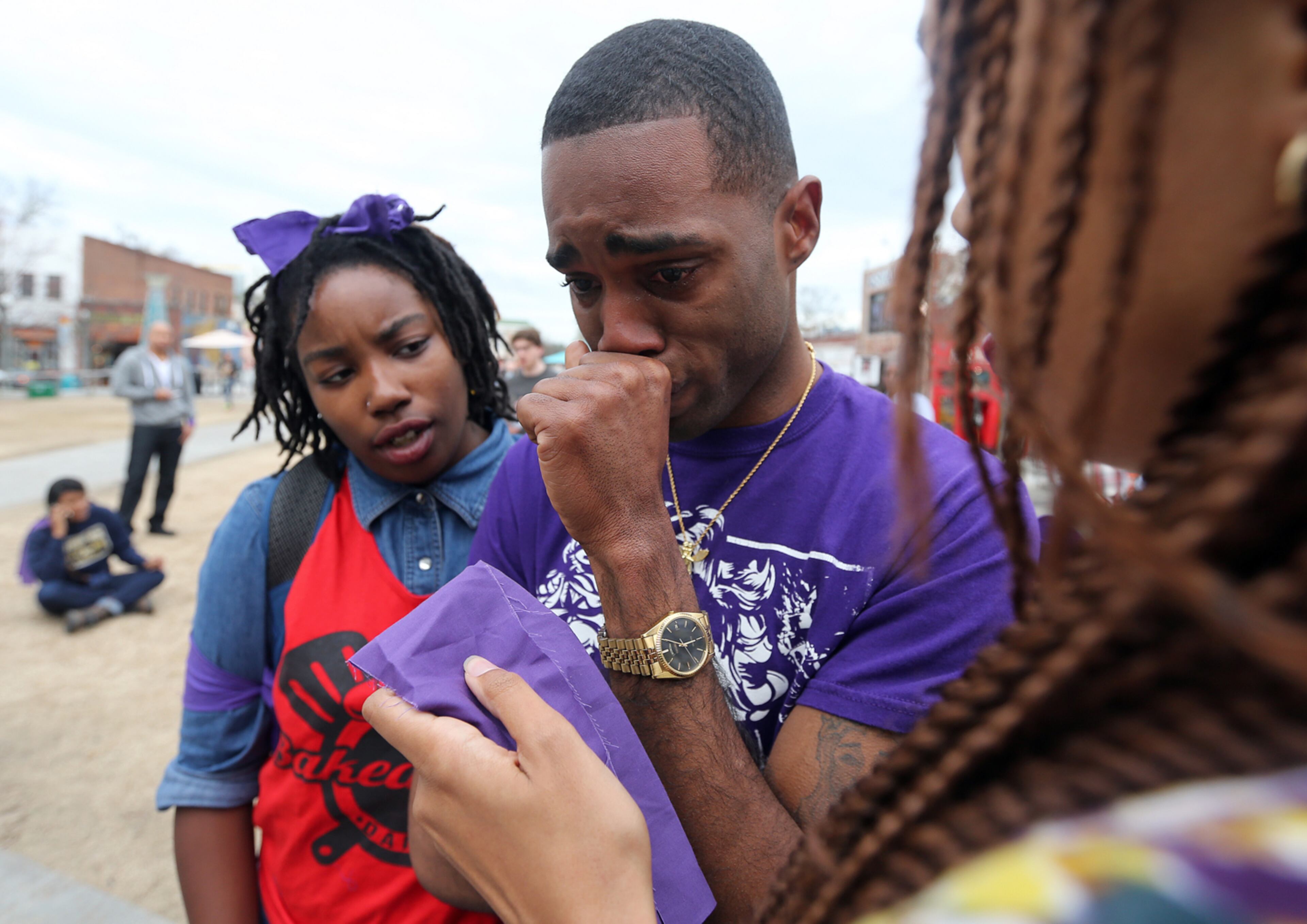 EMOTIONAL MEMORIAL--March 11, 2015 Decatur: Justin Grant, who said he was best friends with Anthony Hill, is overcome with emotion before a rally and vigil in Decatur Square on Wednesday evening March 12, 2015. Grant was so emotional about the loss of his friend that he left before the rally began. Jakalia Brown, left, and Queen K, right comfort him. BEN GRAY / BGRAY@AJC.COM