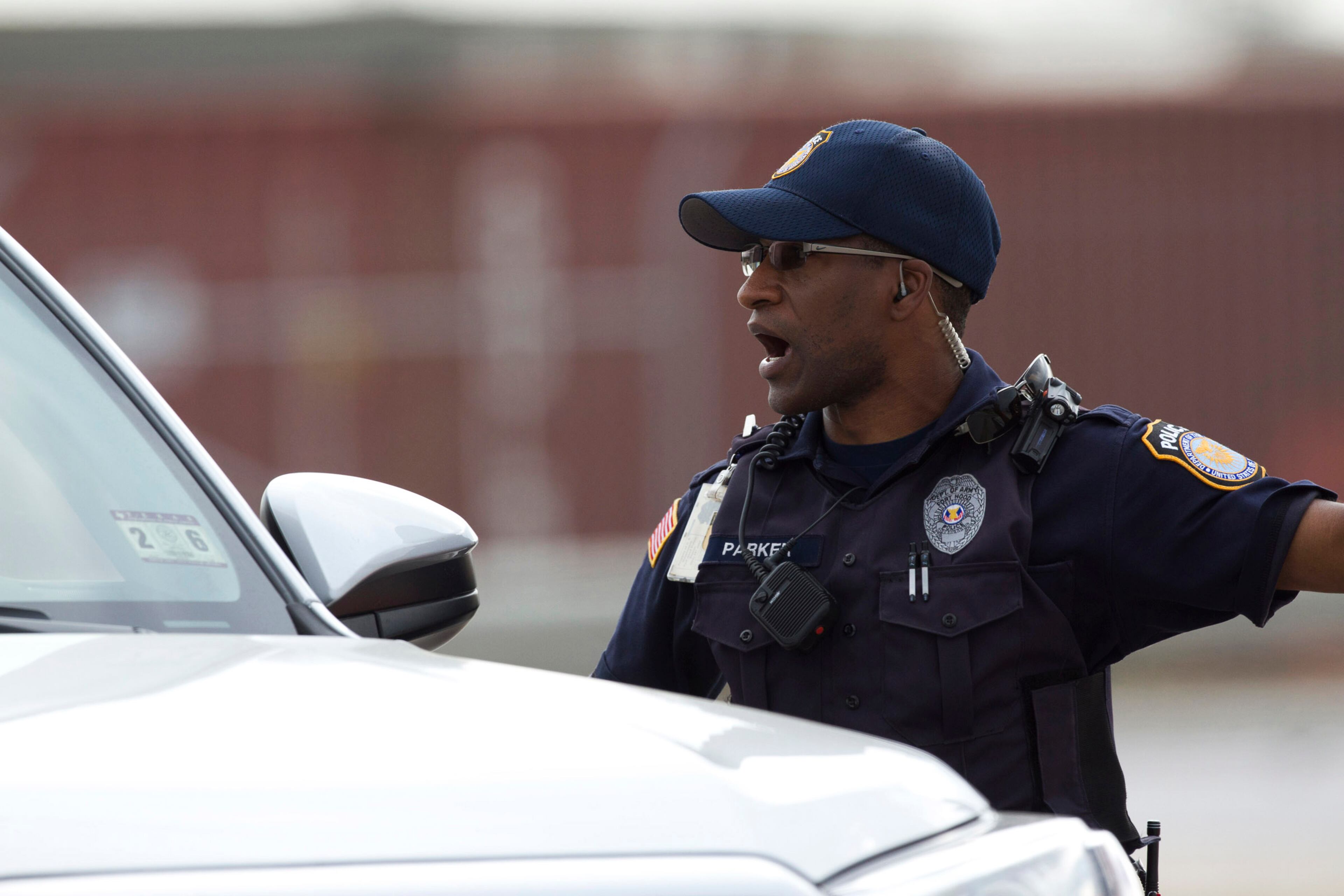 A Fort Hood Police Officer stops a vehicle near the main gate, Wednesday, April 2, 2014, as the military base was placed on lock down in Fort Hood, Texas. One person was killed and 14 injured in the shooting, and officials at Fort Hood said the shooter is believed to be dead. The details about the number of people hurt came from two U.S. officials who spoke on condition of anonymity because they were not authorized to discuss the information by name. (AP Photo/The Temple Daily Telegram, Rusty Schramm)