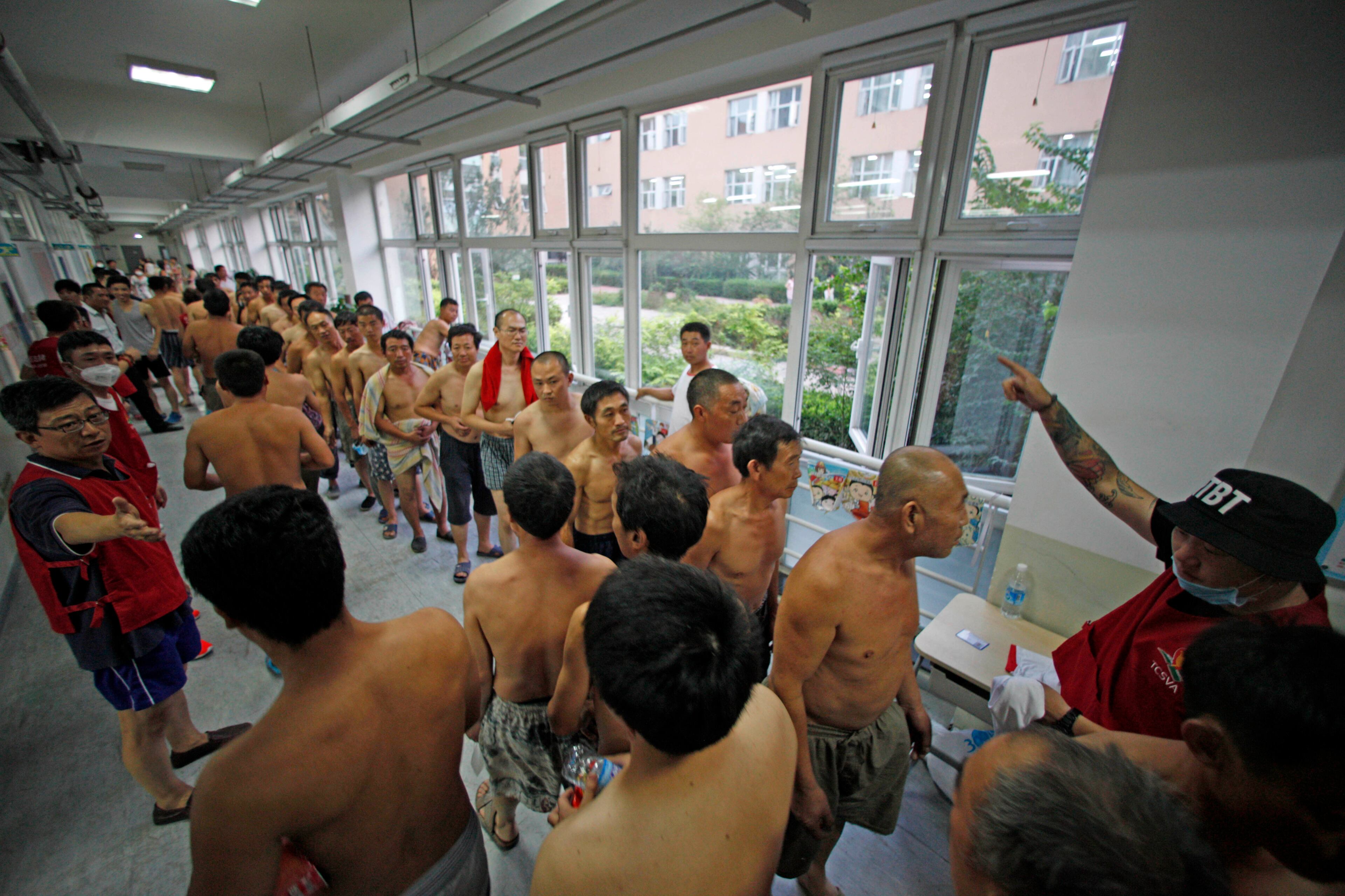 Evacuees line up for donated clothing at a temporary shelter at a primary school following explosions in northeastern China's Tianjin municipality Aug. 13, 2015. Chinese state media reported huge explosions at the Tianjin port late Wednesday.