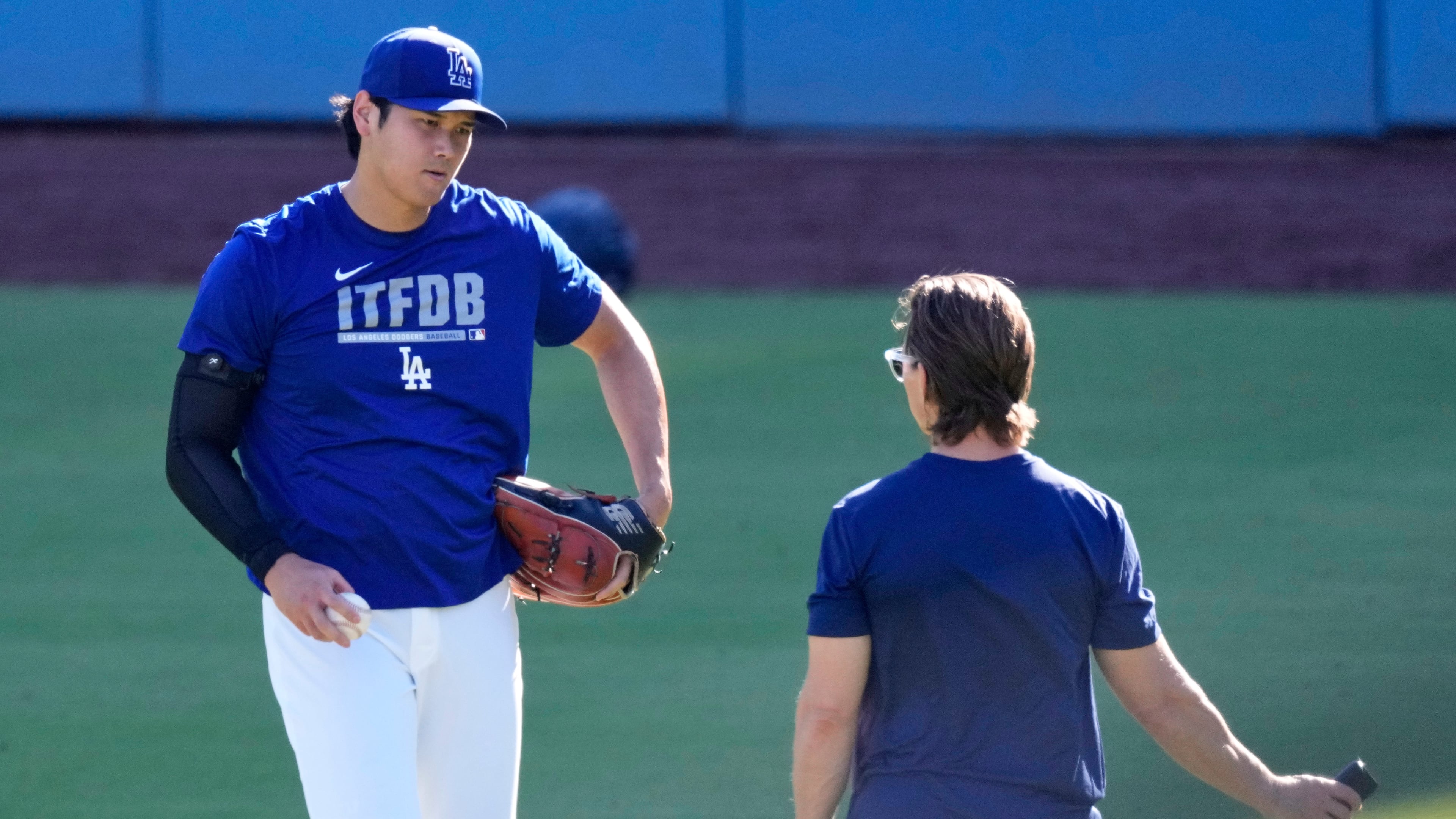 Los Angeles Dodgers' Shohei Ohtani warms up with a trainer prior to a baseball game against the Pittsburgh Pirates, Friday, Aug. 21, 2026, in Los Angeles. (AP Photo/Mark J. Terrill)