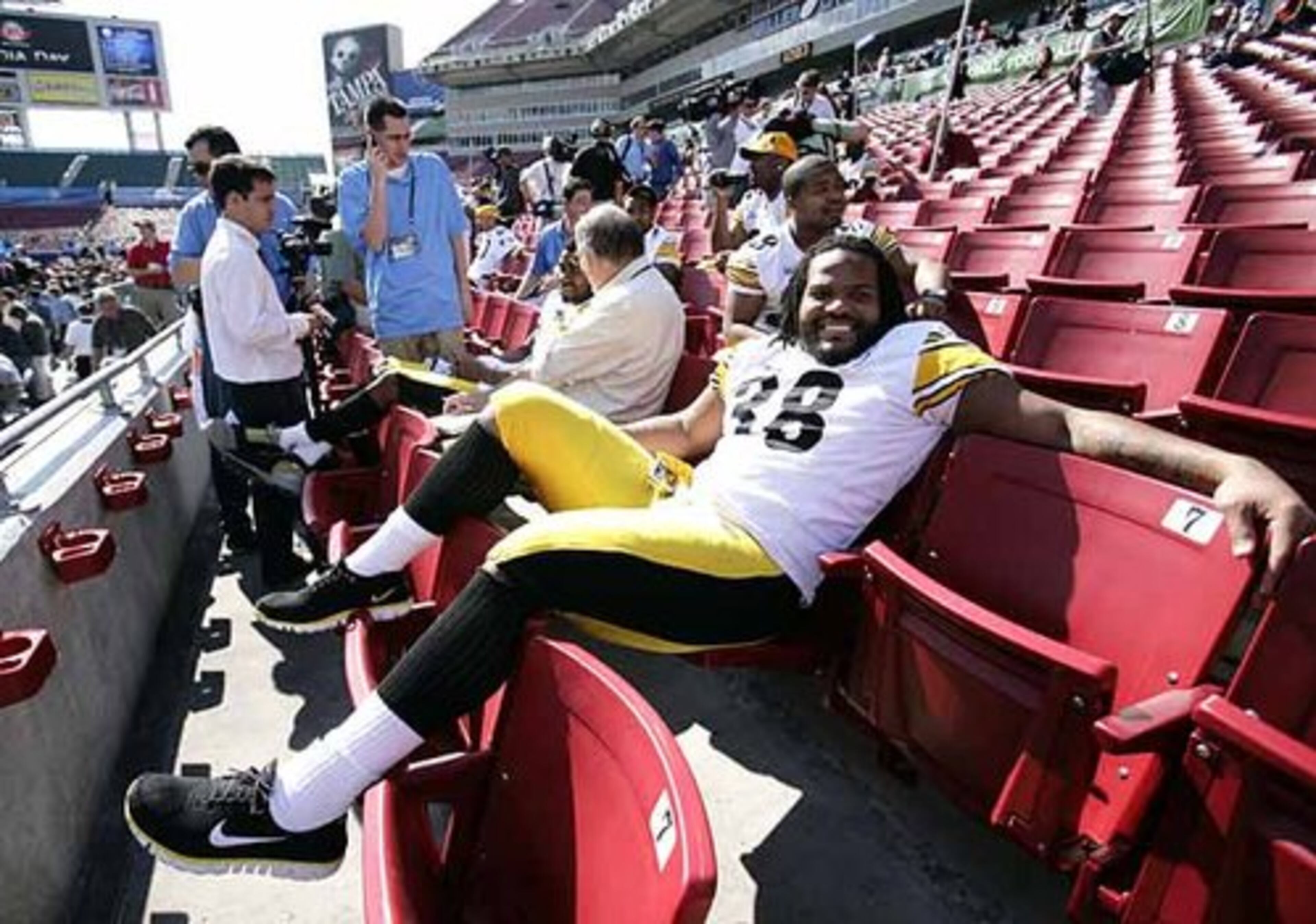 As reporters interview a teammate, Steelers running back Carey Davis (38) relaxes during a lull in the media day hubbub.