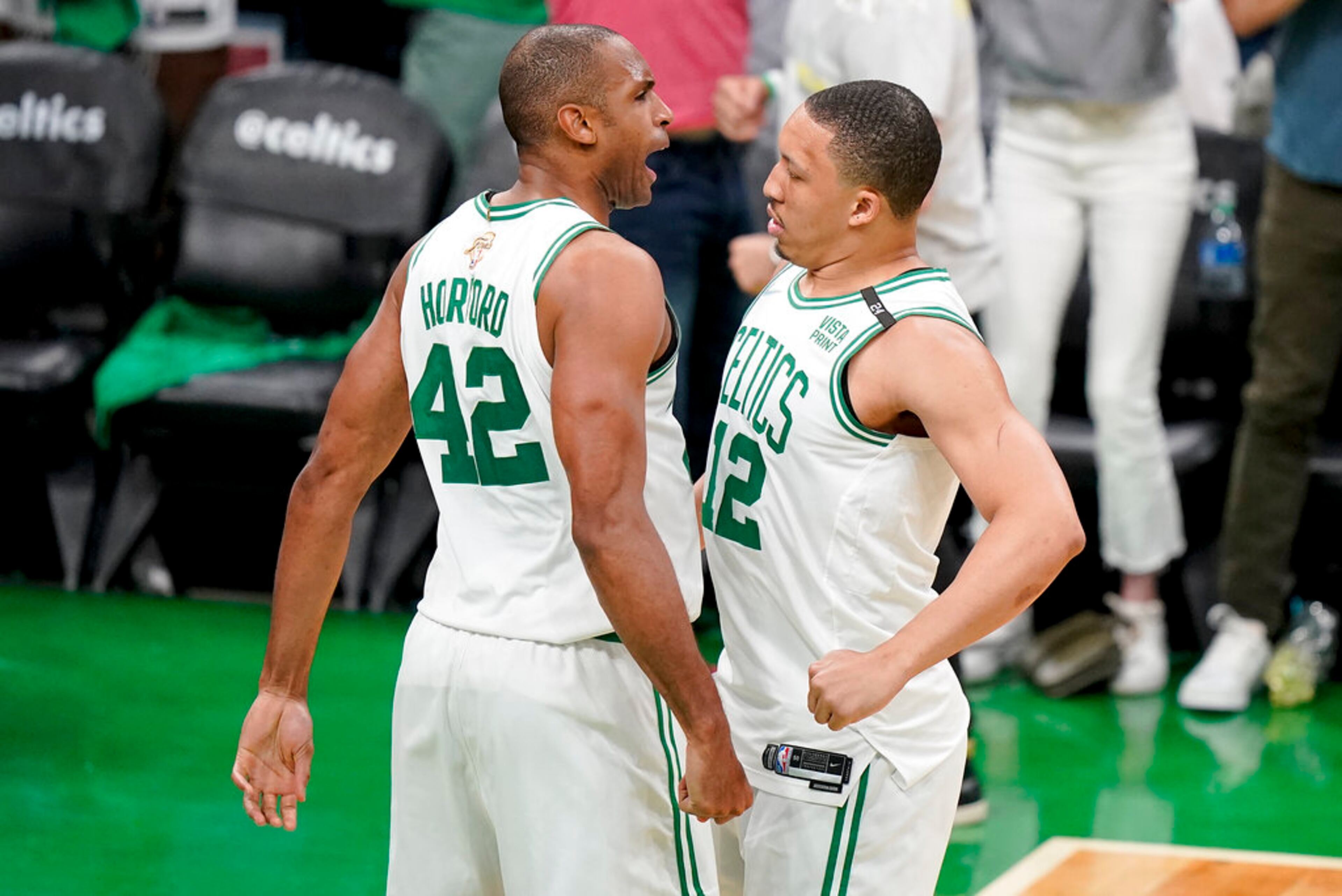 Boston Celtics center Al Horford (42) and forward Grant Williams (12) react during the third quarter of Game 6 of basketball's NBA Finals against the Golden State Warriors, Thursday, June 16, 2022, in Boston. (AP Photo/Steven Senne)
