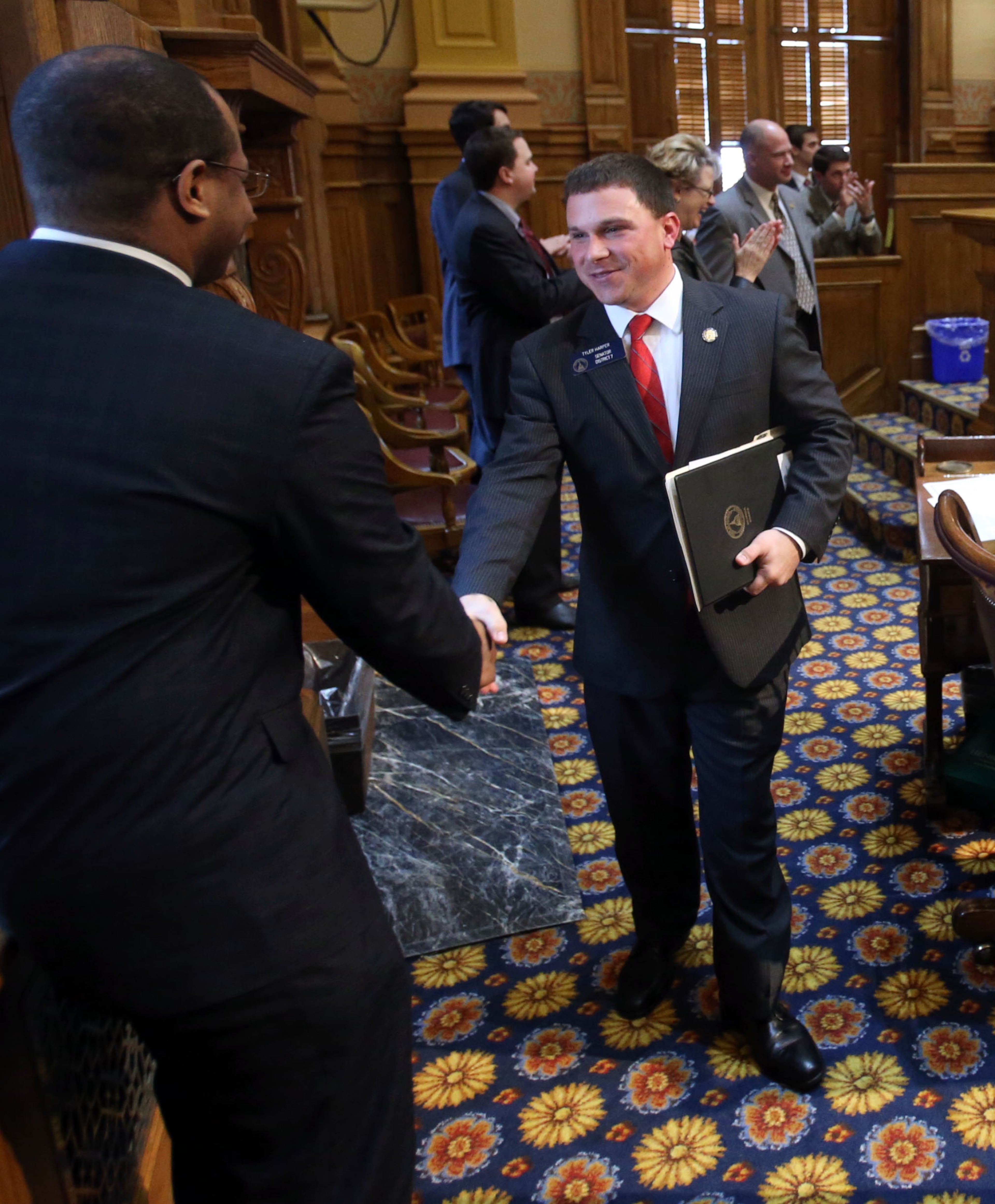 Freshman Sen. Tyler Harper, R-Ocilla, center, is greeted by a lawmaker after he was "hazed" during his first bill, Senate Bill 91, Wednesday, Feb. 13. Every time a freshman senator sponsors a first bill fellow senators "haze" them in the Senate chambers as a sort of rite of passage.