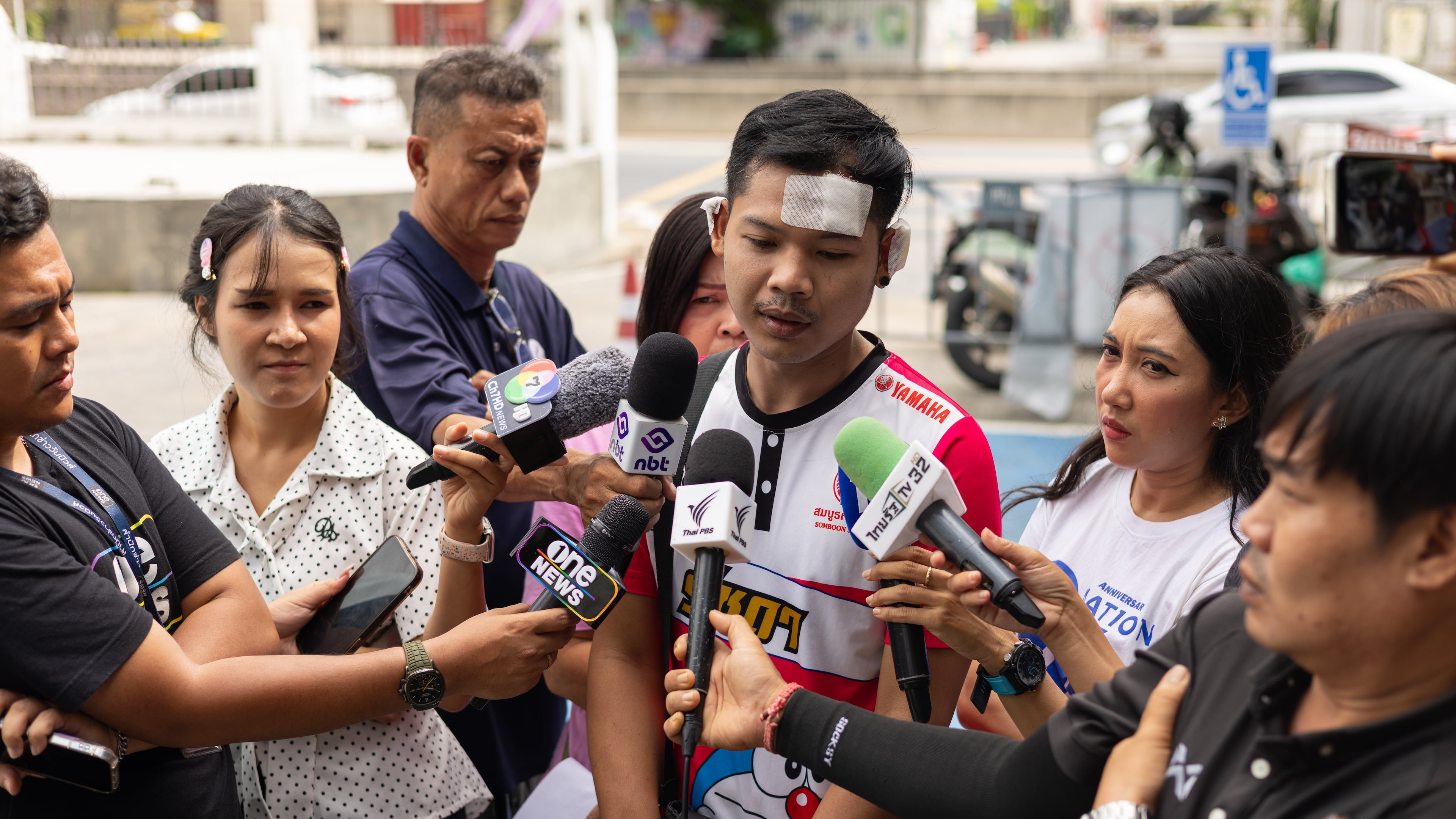 Natthaphong Lakhorn, a 26-year-old survivor of the Rong Beer Na Ladprao bar fire, speaks to journalists outside the Phahonyothin Police Station in Bangkok, Thailand, Wednesday, July 15, 2026. (AP Photo/Anton L. Delgado)