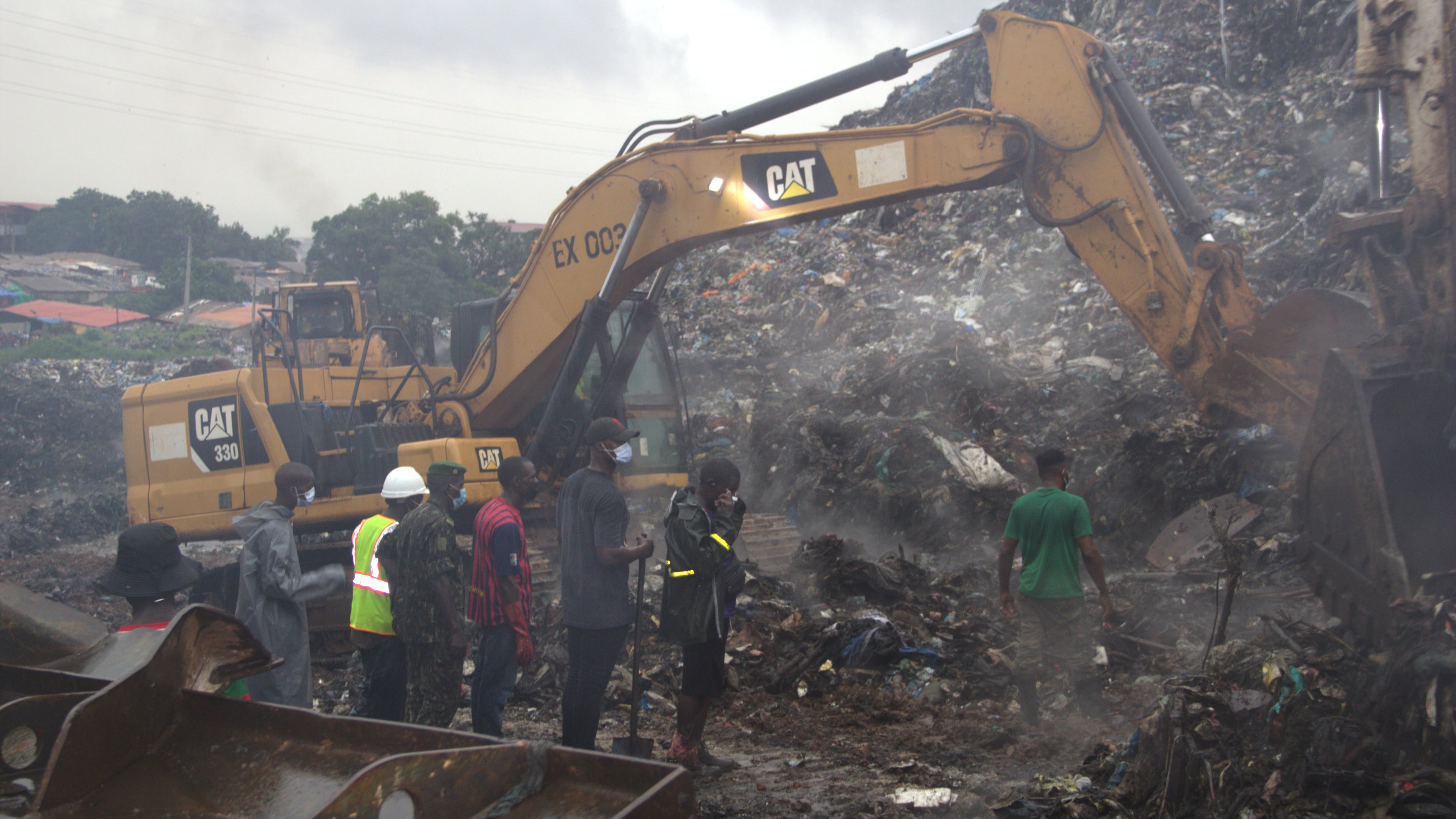 Rescue workers search through a heap of refuse after it collapsed at Conakry’s largest landfill, Guinea, Sunday, Aug. 23, 2026. (AP Photo/Fodo Toure)