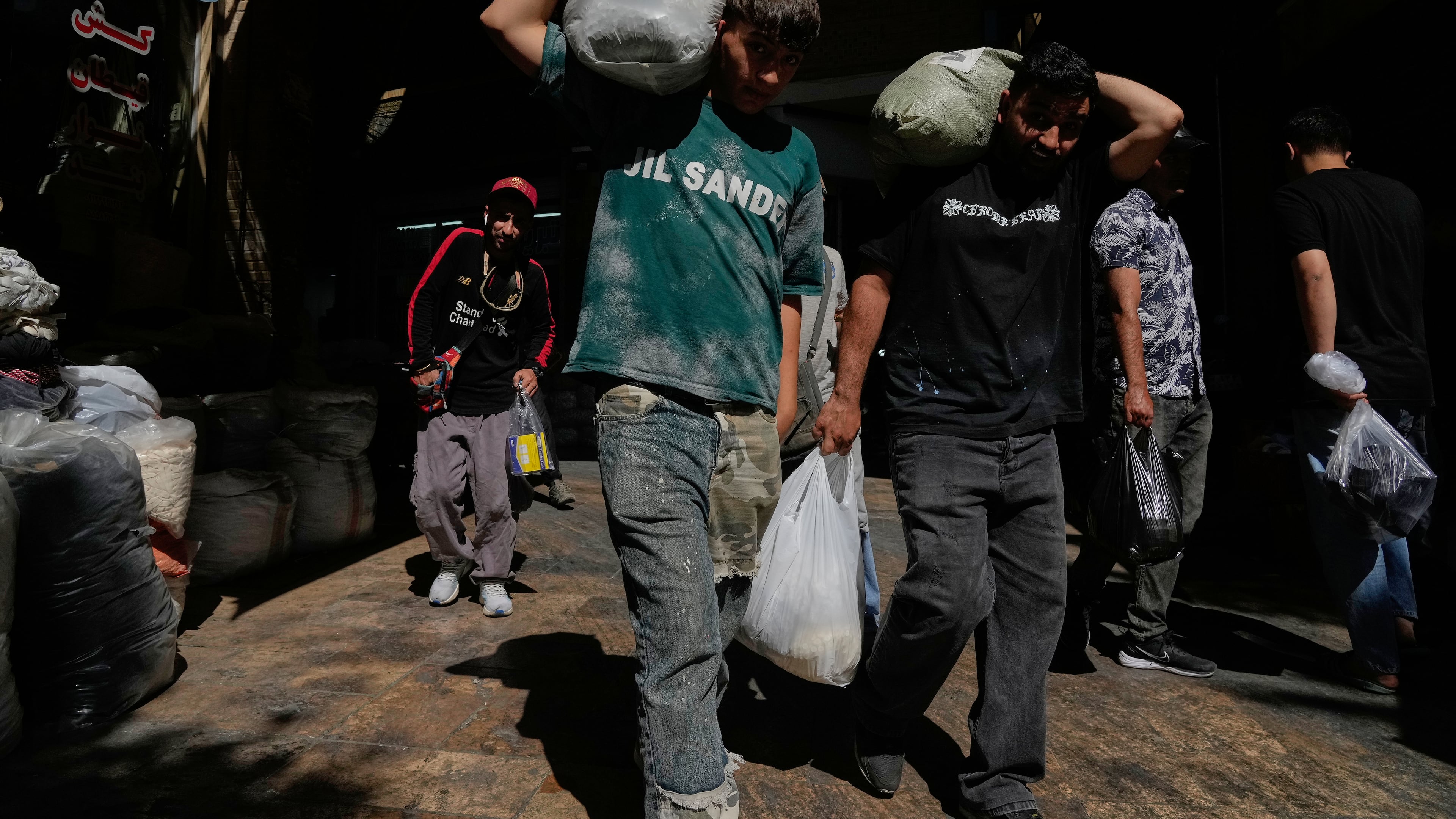 People carry packages at Tehran's historic Grand Bazaar, Iran, Monday, June 1, 2026. (AP Photo/Vahid Salemi)