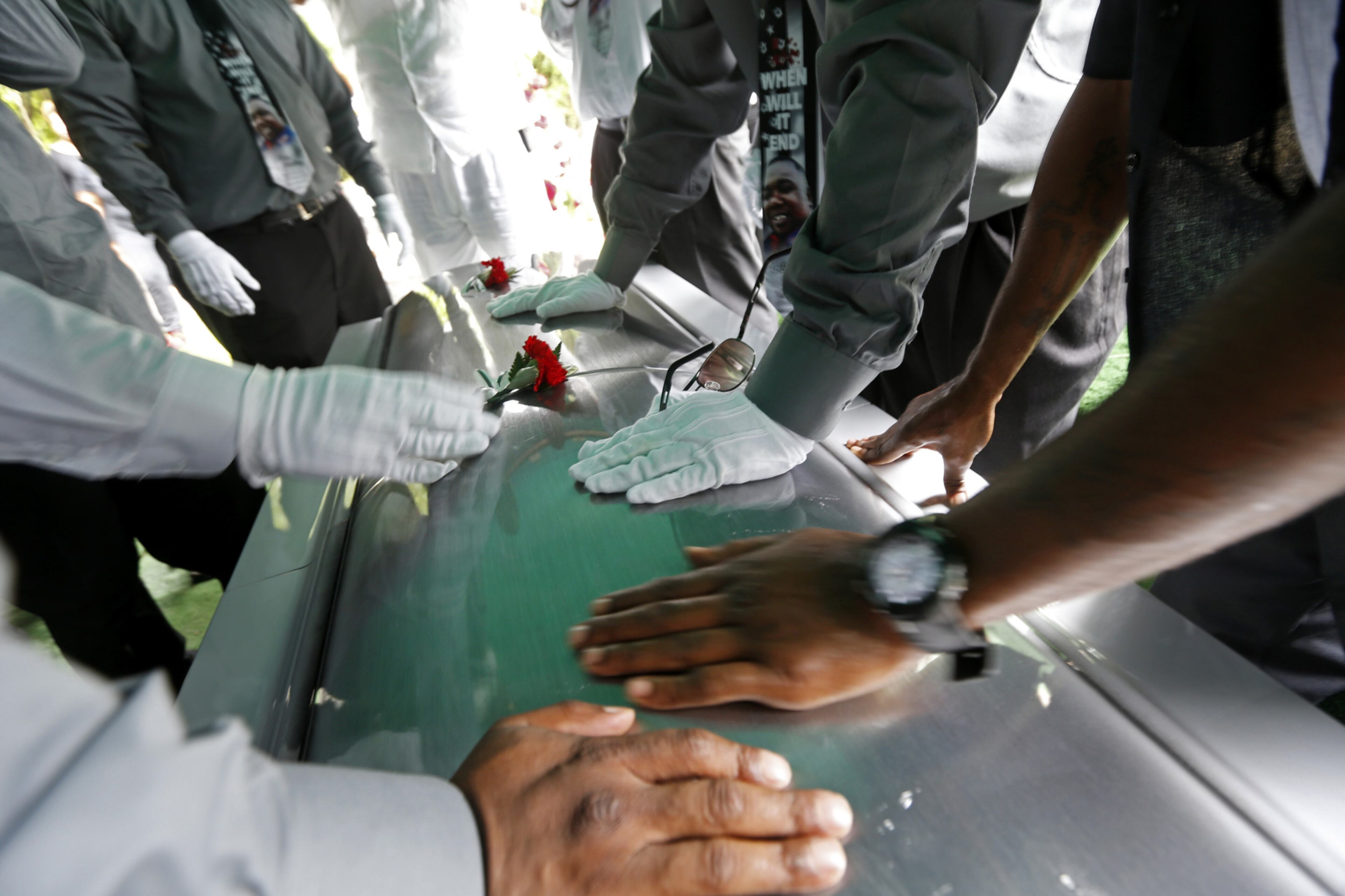 BATON ROUGE, LA - JULY 15: Pall bearers touch the casket of Alton Sterling after placing the casket at the internment site at the Mount Pilgrim Benevolent Society Cemetery July 15, 2016 in Baton Rouge, Louisiana. Sterling was shot July 5 outside a Baton Rouge convenience store in an encounter with police that was caught on video. (Photo by Gerald Herbert-Pool/Getty Images)