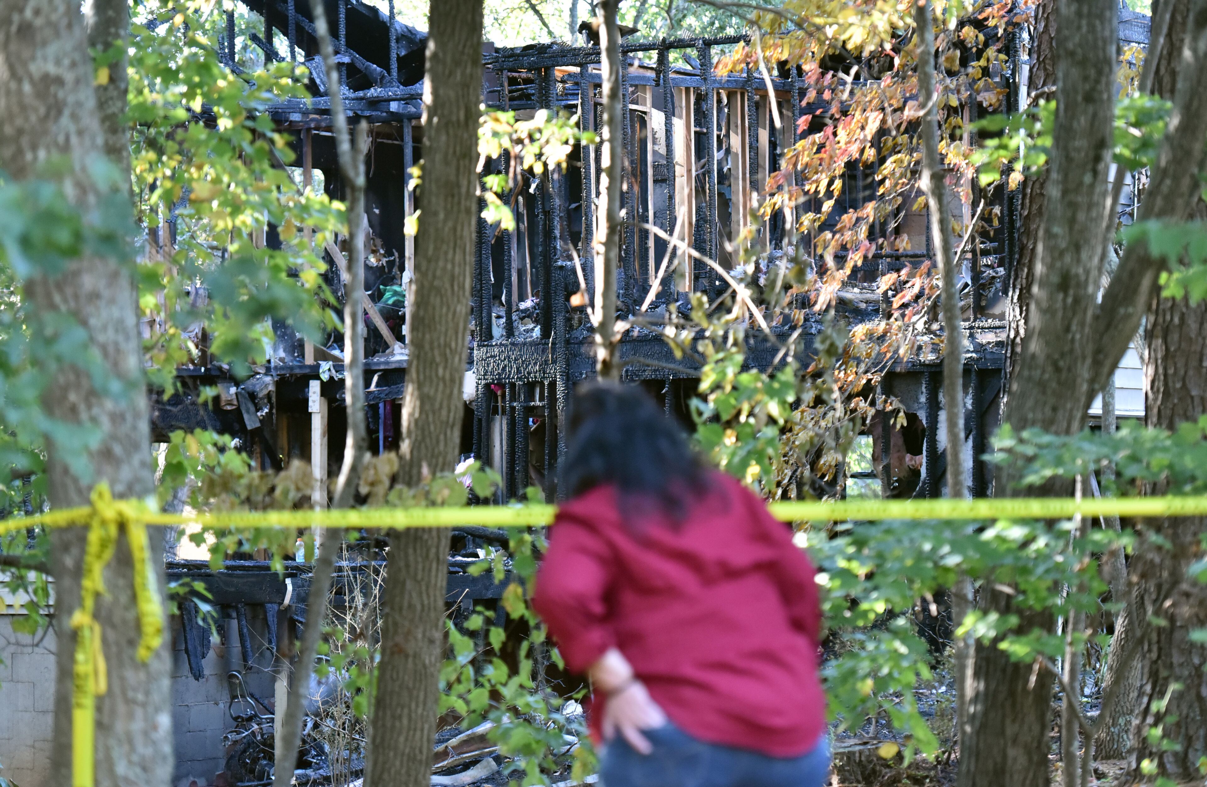 October 23, 2016 Duluth - A neighbor checks out the house where five adults were found dead after a fire gutted the home in the 2200 block of Post Oak Drive in unincorporated Duluth early Sunday morning on Sunday, October 23, 2016. Five people are dead after a fire gutted a home in unincorporated Duluth early Sunday morning, Gwinnett County fire officials said. Gwinnett County Department of Fire and Emergency Services Capt. Tommy Rutledge confirmed that five adults were found dead in the home in the 2200 block of Post Oak Drive NW, a two-story structure in the middle of a dead-end street near Old Peachtree Road. HYOSUB SHIN / HSHIN@AJC.COM