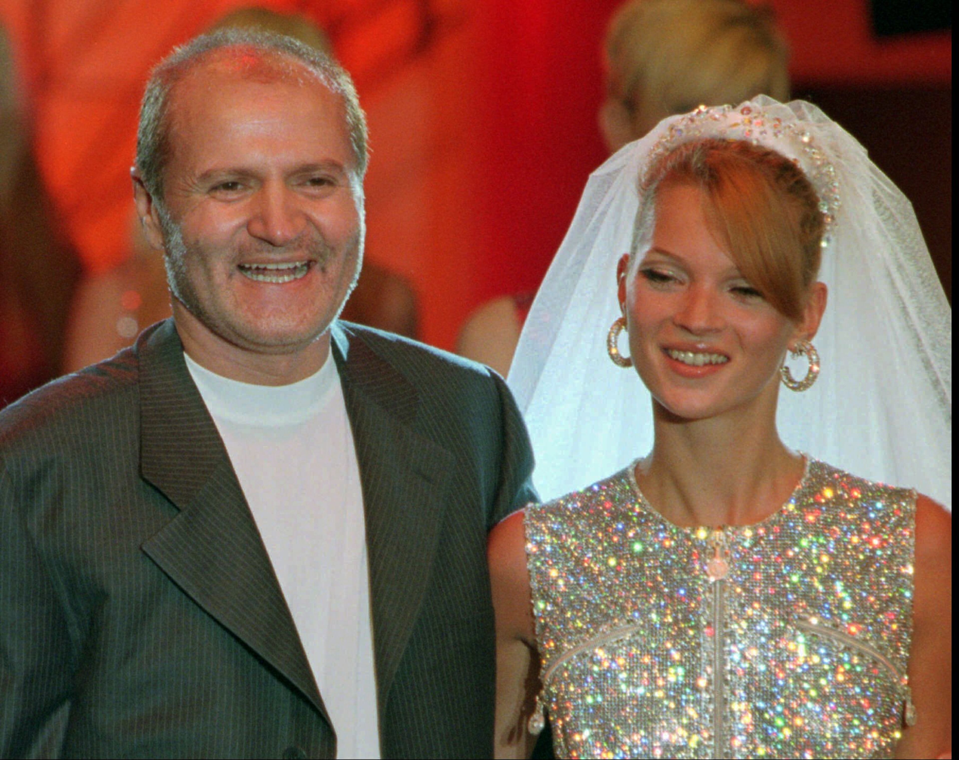 Italian fashion designer Gianni Versace, left, smiles with British model Kate Moss wearing the wedding gown after the presentation of his fall/winter 1995/96 haute couture collection, in Paris, France on Saturday July 8, 1995. Versace was recently indicted along with other Italian fashion designers for allegedly bribing Italian tax inspectors.