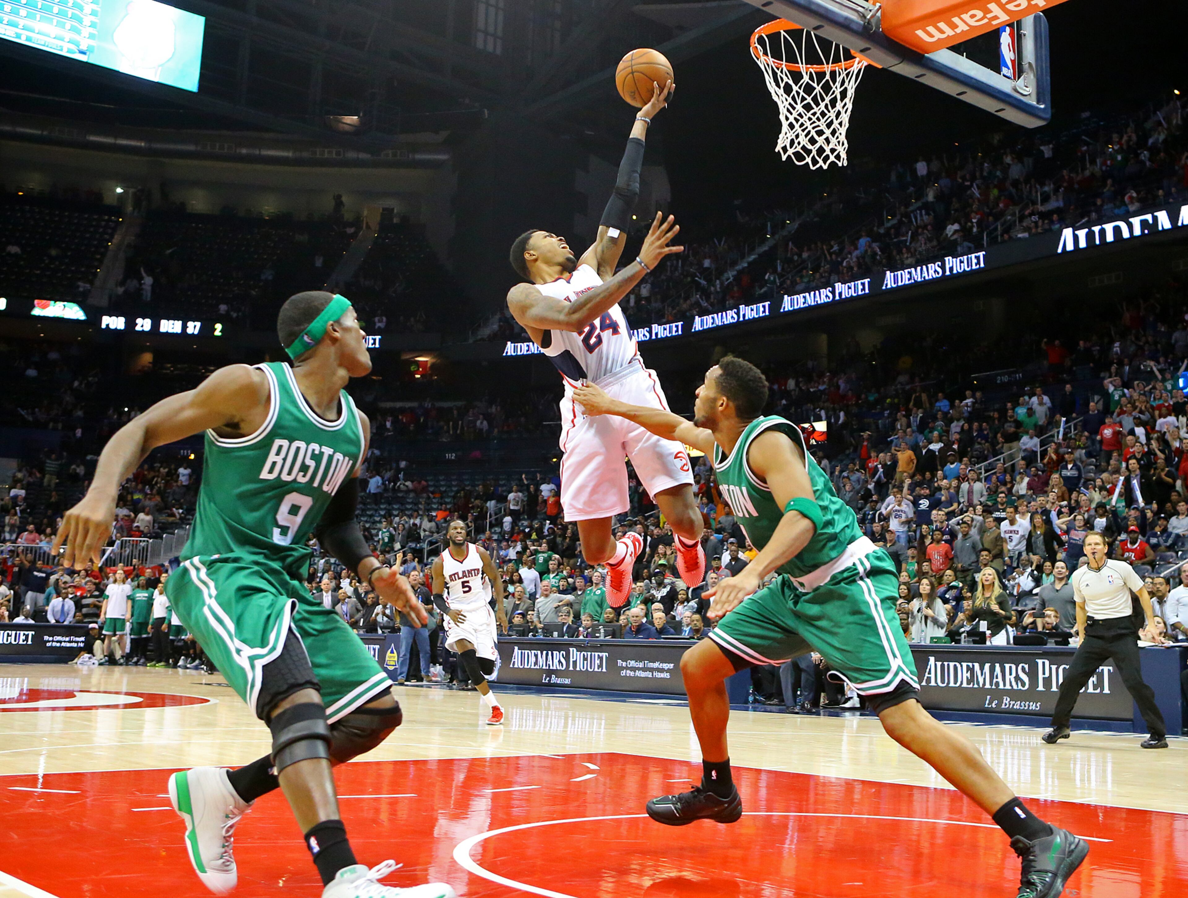 Hawks guard Kent Bazemore takes it to the basket for two points past Celtics Rajon Rondo (left) and Evan Turner for the final two points of the game in the closing seconds for a 109-105 Hawks victory in an NBA basketball game on Tuesday, Dec. 2, 2014, in Atlanta. CURTIS COMPTON / CCOMPTON@AJC.COM