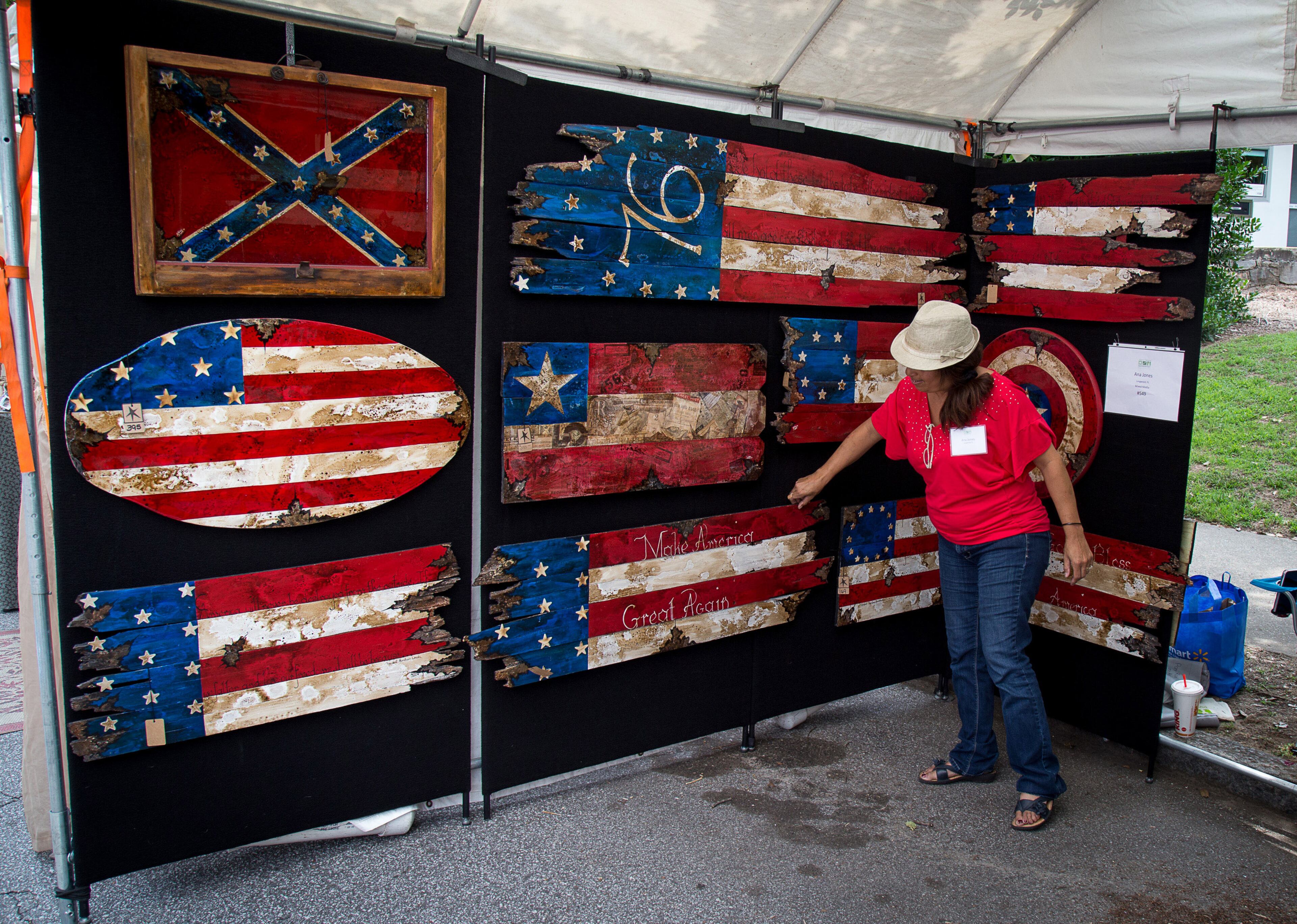Ana V Jones straitens one of her flag paintings in her booth at the Summerfest in Atlanta on Saturday, June 4, 2016. STEVE SCHAEFER / SPECIAL TO THE AJC