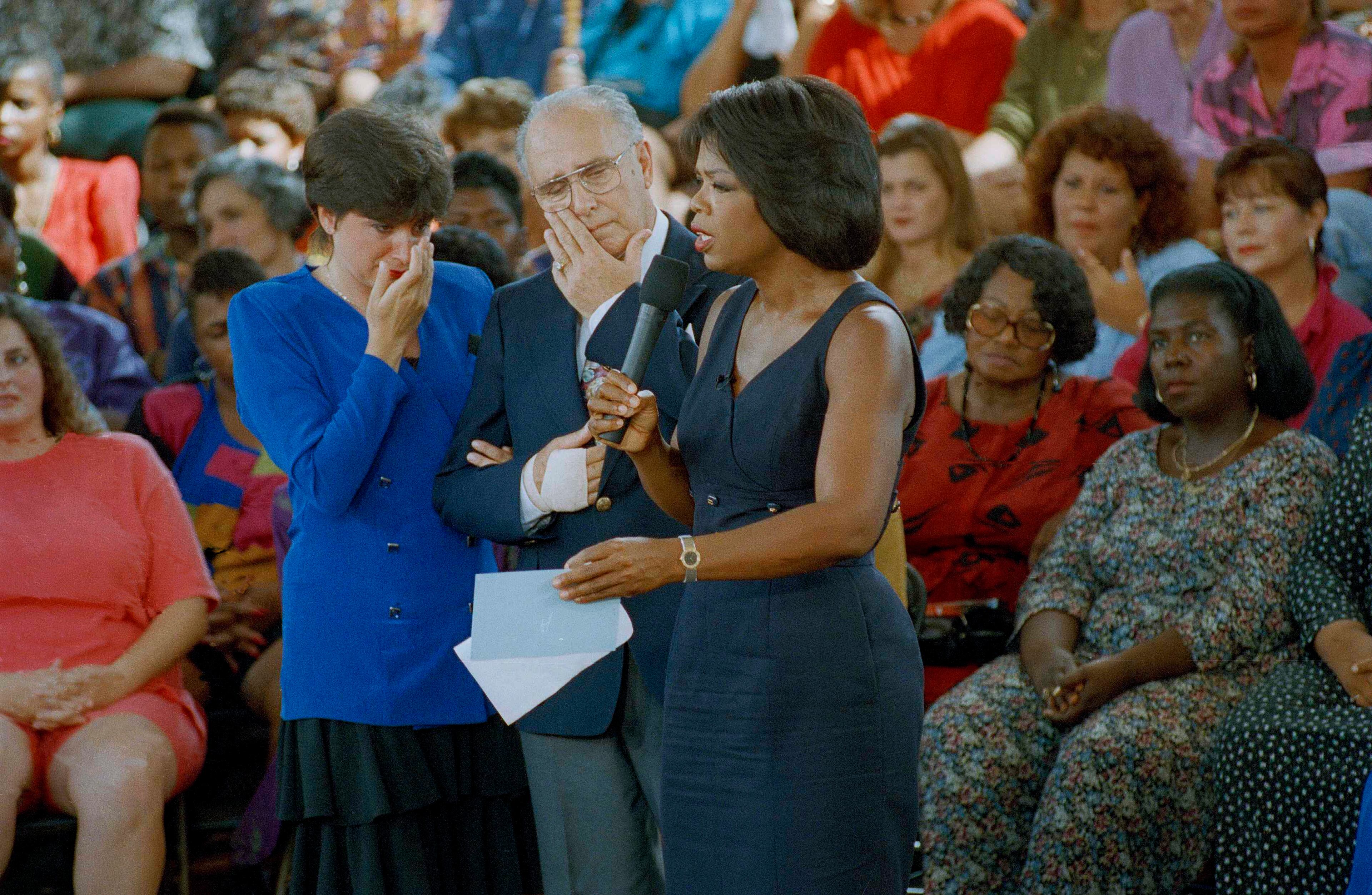 Canadians Lucy Nadeau, left, and father-in-law Armand Nadeau, center, of Montreal, wipe tears from their eyes, as they talk with Oprah Winfrey during the taping of her talk show in Miami, Fla., Sept. 13, 1993. Nadeau's husband was shot to death during a robbery in Forth Worth, Fla. last December while her 5-year-old son looked on and his father, Armand was shot in the back and as a result his right arm is paralyzed. Winfrey brought her show to Miami to focus on crimes against tourists after Uwe-Eilhelm Rakebrand of Germany was shot to death last week outside Miami International Airport. (AP Photo/Ray Fairall)