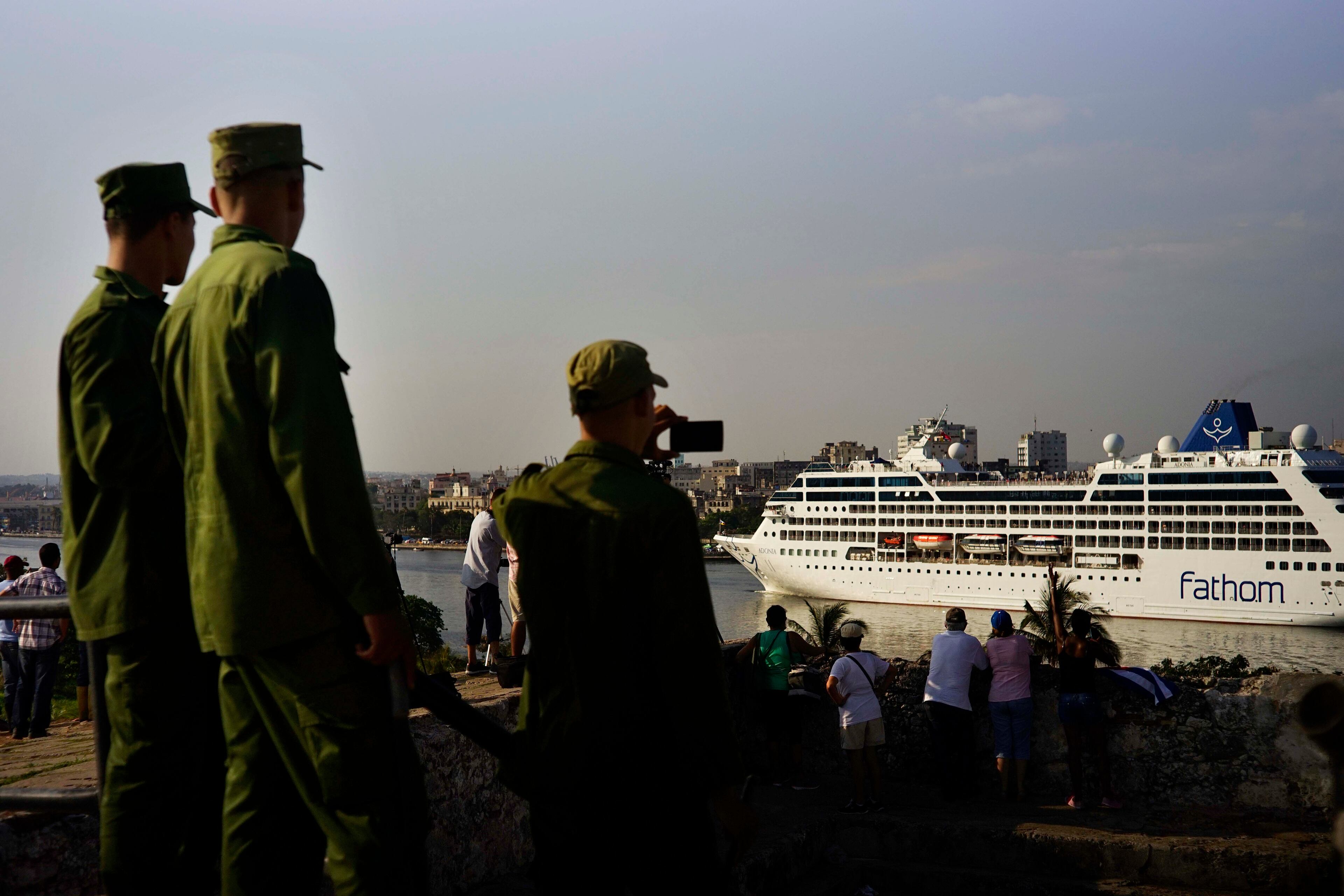 Cuban soldiers watch the Carnival Adonia cruise ship arrive from Miami, in Havana, Cuba, Monday, May 2, 2016. The Adonia's arrival is the first step toward a future in which thousands of ships a year could cross the Florida Straits, long closed to most U.S.-Cuba traffic due to tensions that once brought the world to the brink of nuclear war. (AP Photo/Ramon Espinosa)