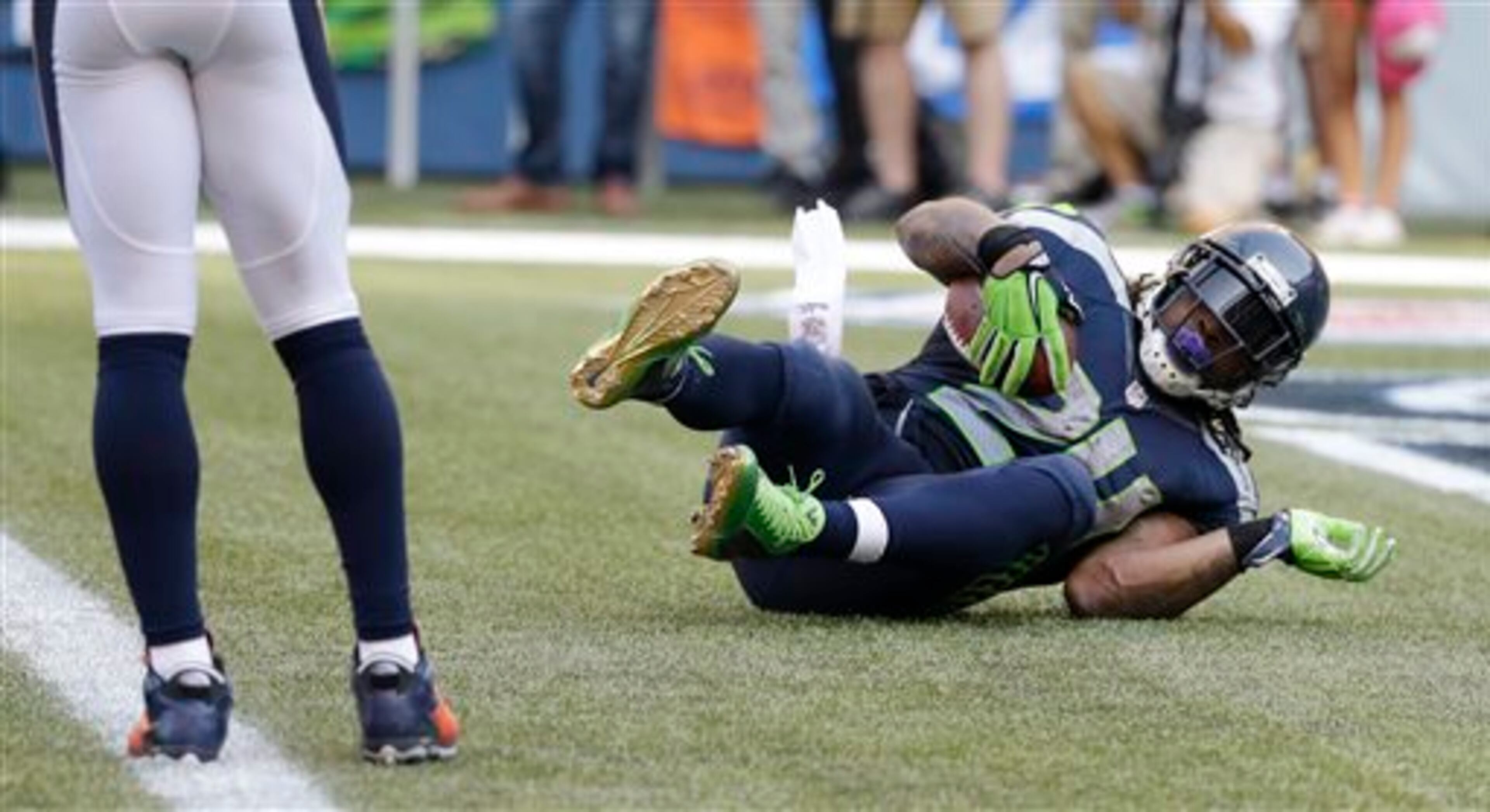 Seattle Seahawks running back Marshawn Lynch scores the game-winning touchdown in overtime of an NFL football game against the Denver Broncos, Sunday, Sept. 21, 2014, in Seattle. The Seahawks defeated the Broncos 26-20. (AP Photo/Elaine Thompson)