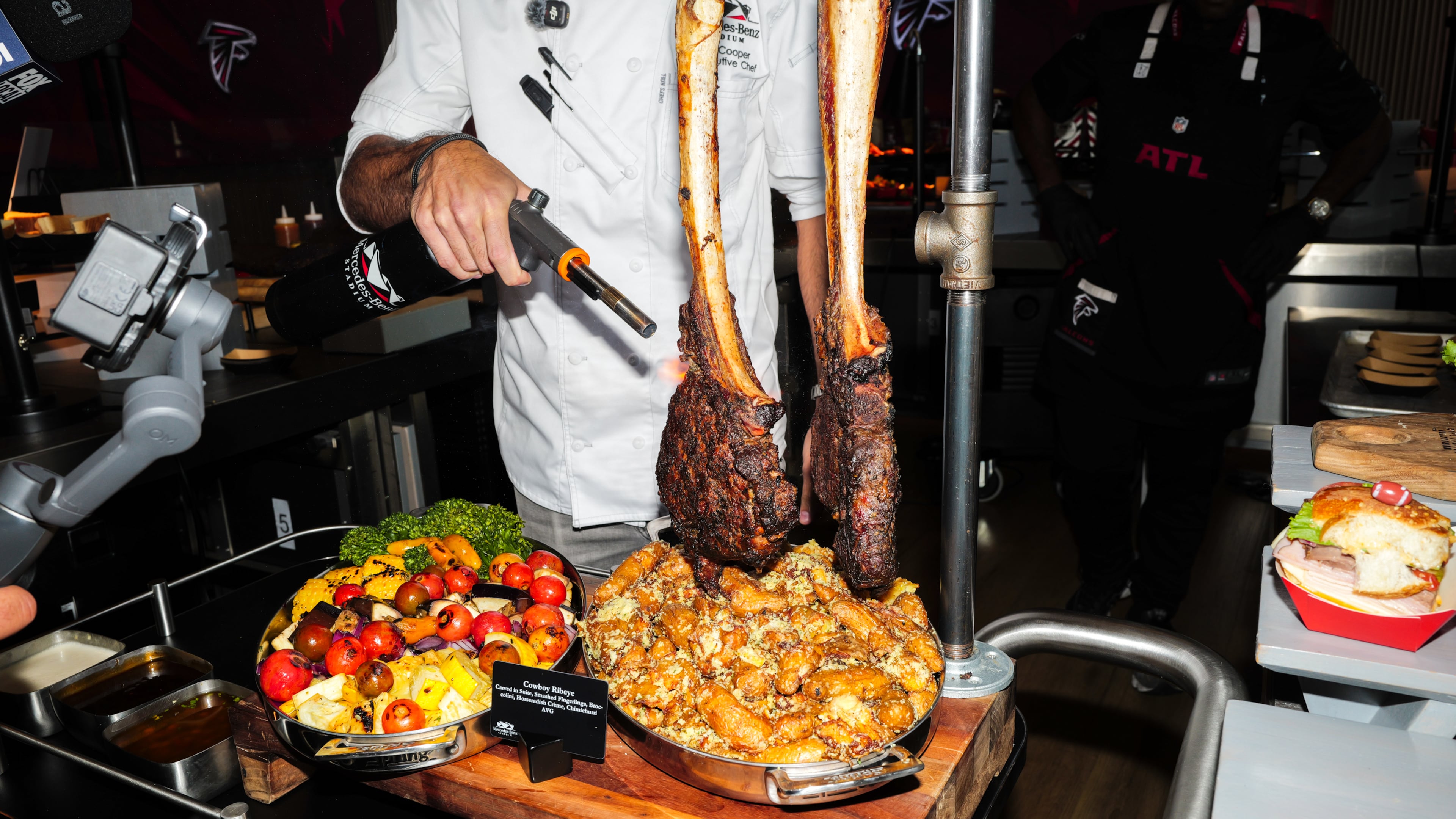 Senior executive chef Matt Cooper torches a steak at a media event showcasing new food and beverage options at Mercedes-Benz Stadium in Atlanta on Sept. 15, 2026, ahead of the Falcons home opener. (Arvin Temkar/AJC)