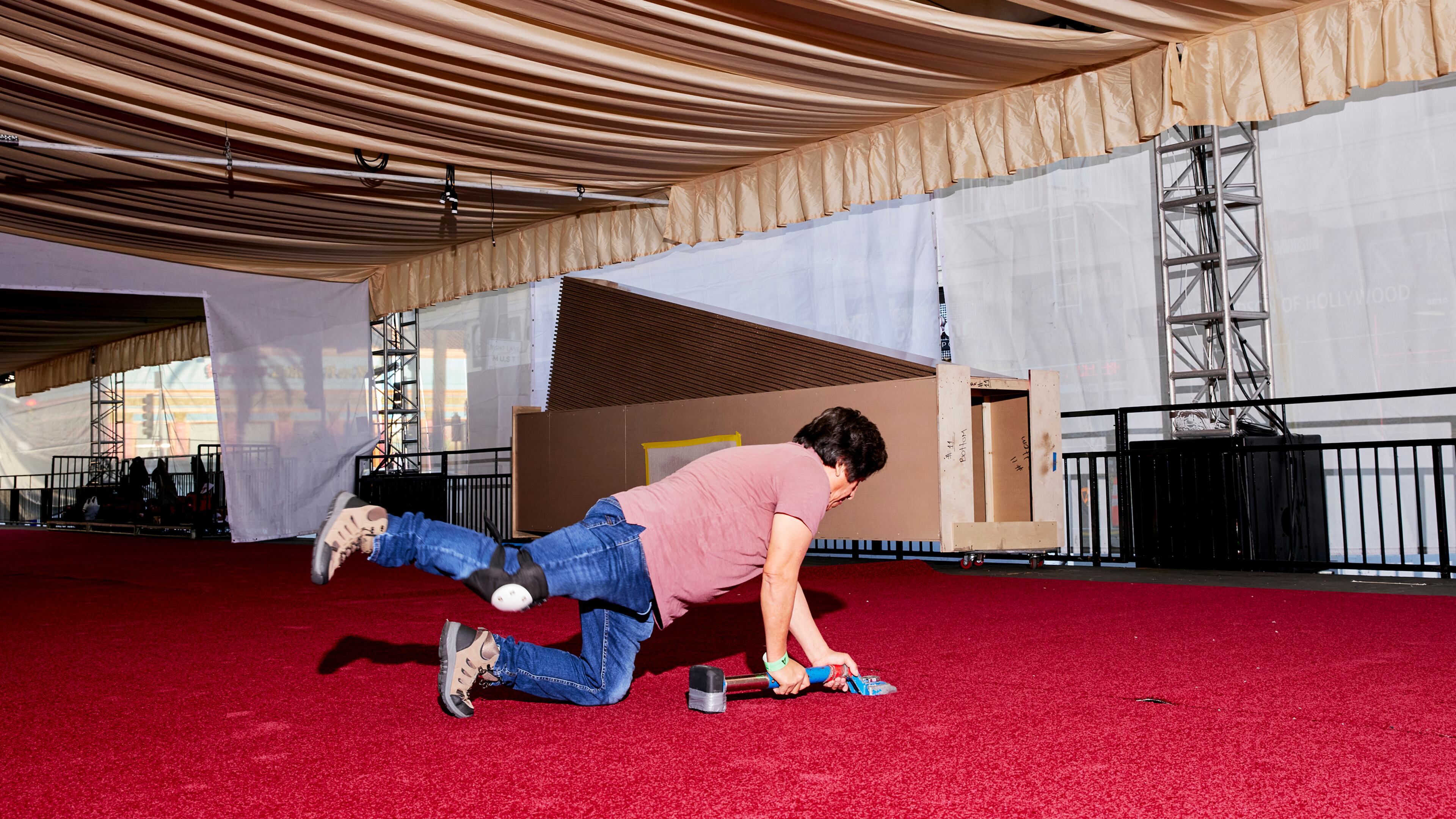 Teams install the red carpet at the Dolby Theater before the Oscars in Los Angeles, on Feb. 21, 2025. Steve Olive, who has worked in the event carpet business for more than three decades, is the man the Academy trusts to get its iconic rug just right. (Jennelle Fong/The New York Times)