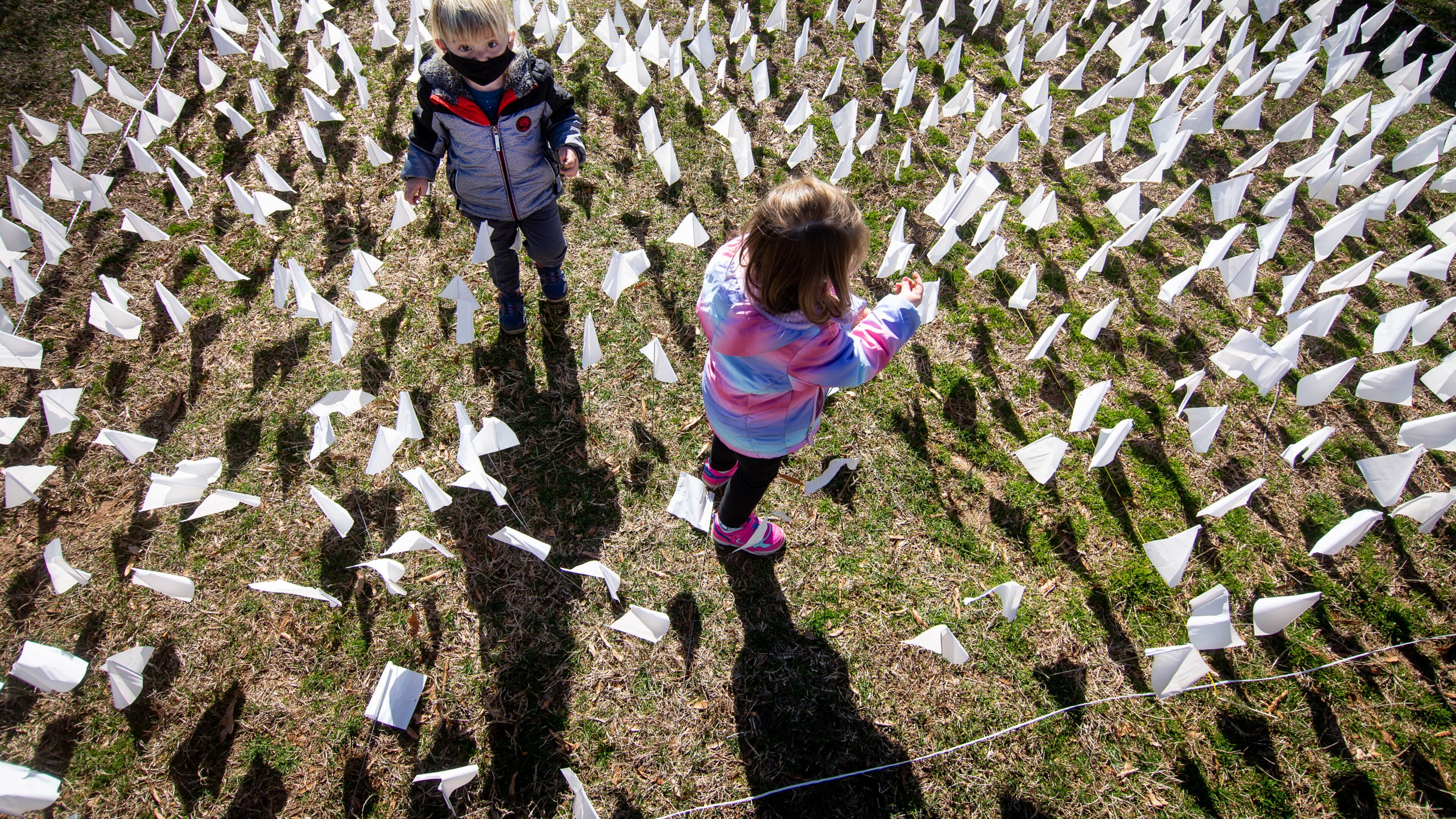 Francis Drenner (left) and his twin sister, Margaret, plant some of the 15,000 flags on the lawn of First Christian Church of Decatur on Saturday. (Photo: Steve Schaefer for The Atlanta Journal-Constitution)