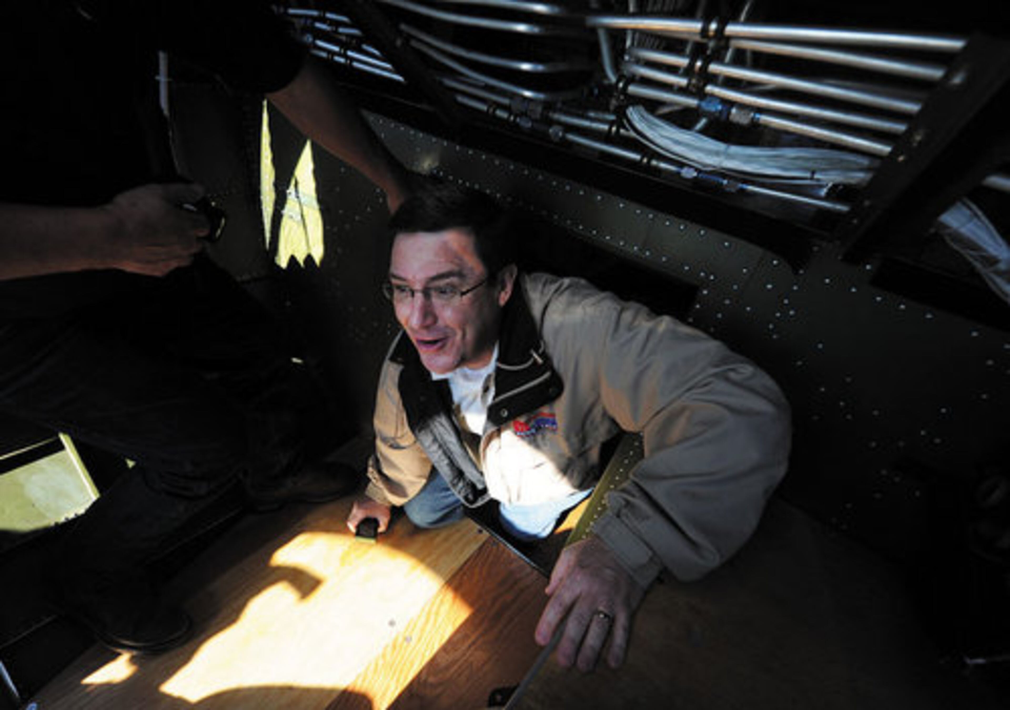 John Stirzaker smiles as he crawls through the plane during a flight.