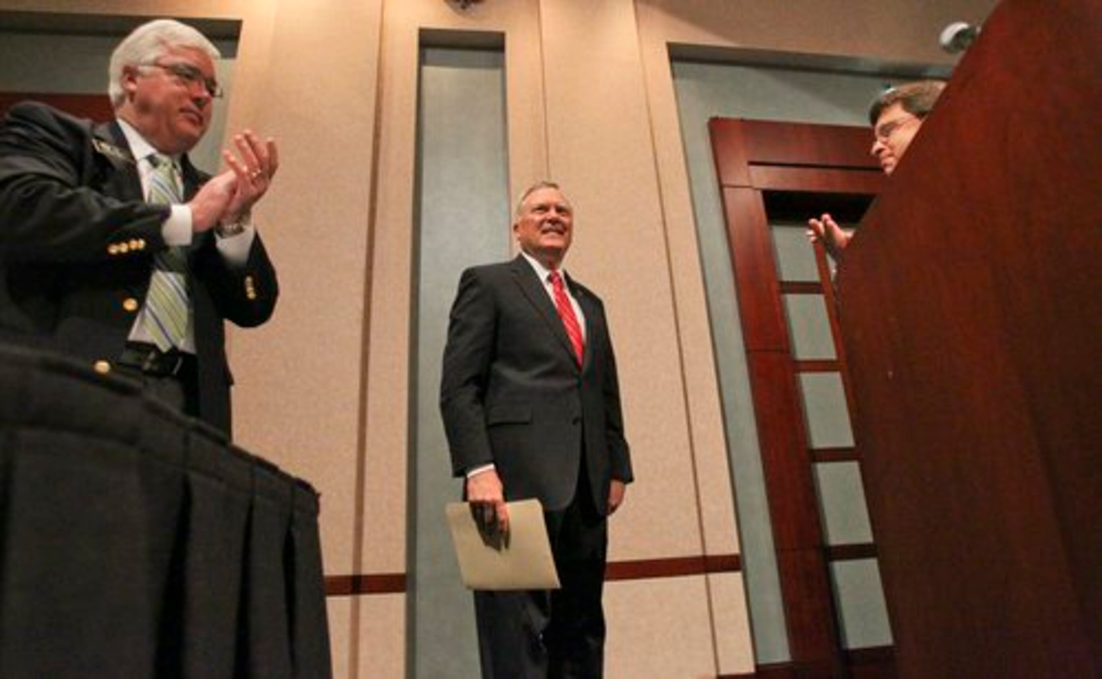 Left to right- Chairman of the Cobb County Board of Commissioners, Tim Lee, Georgia State Governor, Nathan Deal and Bank of North Georgia's, Rob Garcia applaud Deal following his speech Monday.