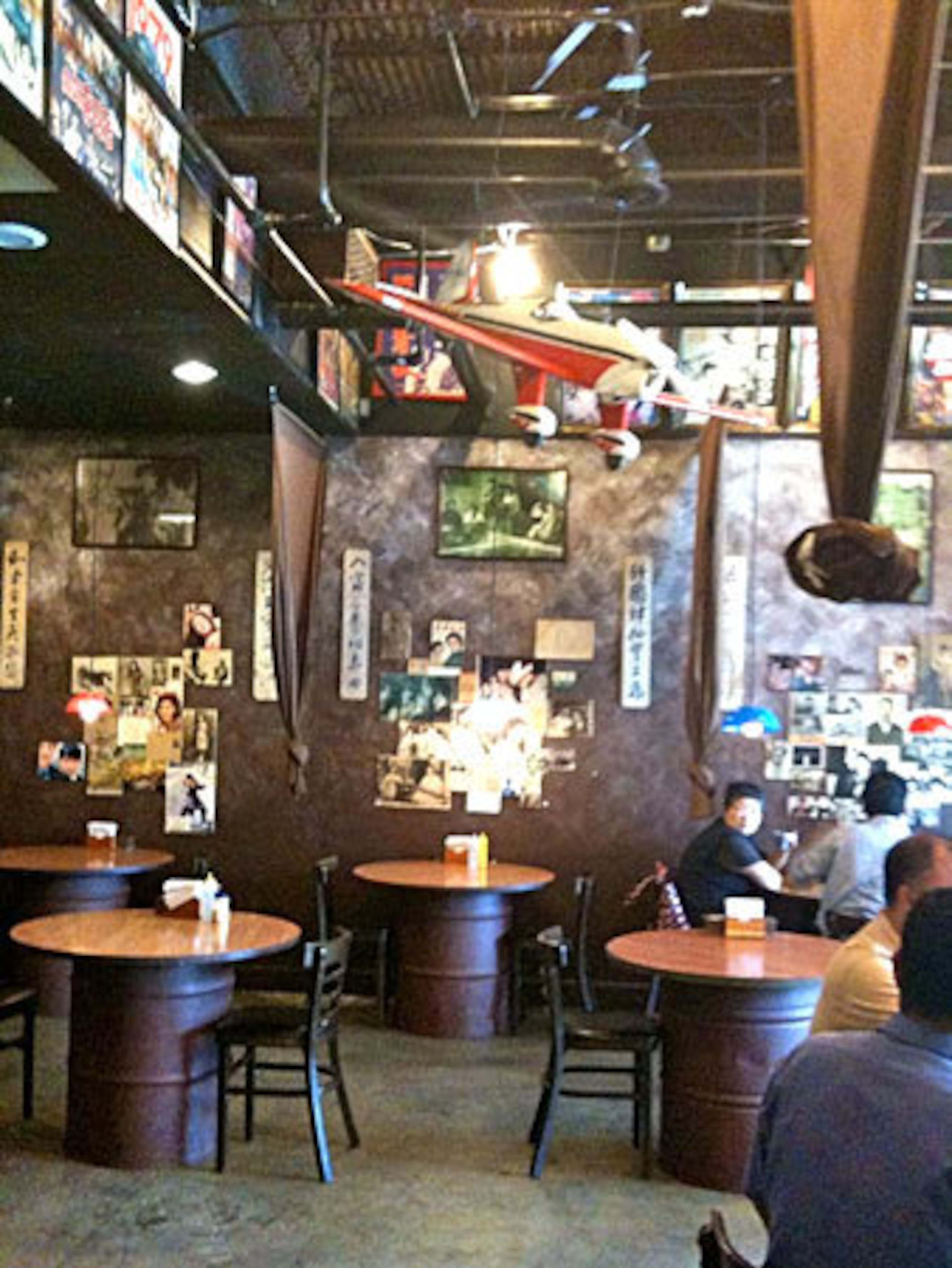 Harm Heung Cold Noodle, a restaurant evocatively decorated with Korean War memorabilia, including tables made from plywood rounds set over oil drums and a model aircraft that is suspended from the ceiling.