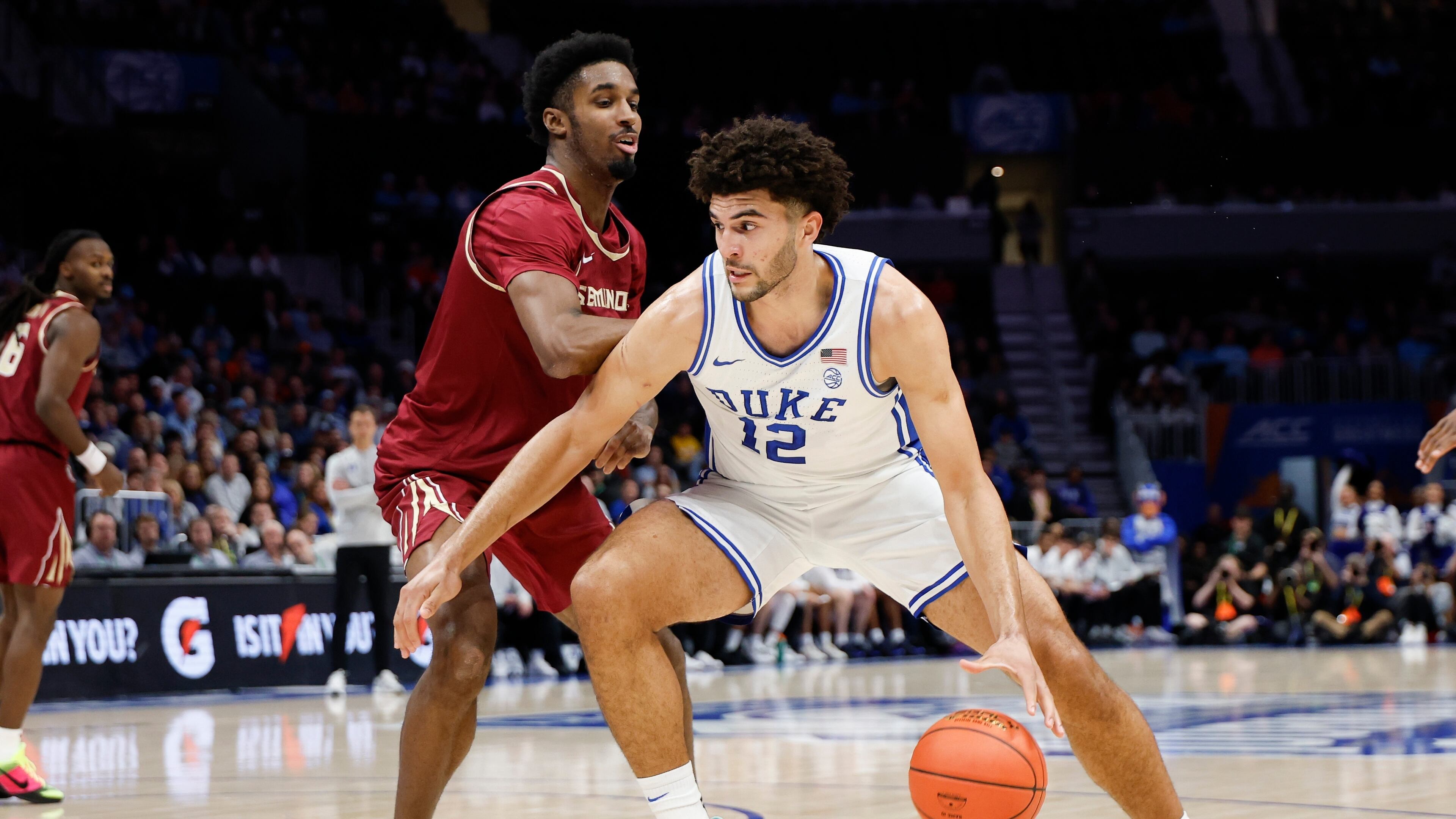 Duke forward Cameron Boozer (12) drives against Florida State forward Chauncey Wiggins during the first half of an NCAA college basketball game in the quarterfinals of the Atlantic Coast Conference tournament in Charlotte, N.C., Thursday, March 12, 2026. (AP Photo/Nell Redmond)