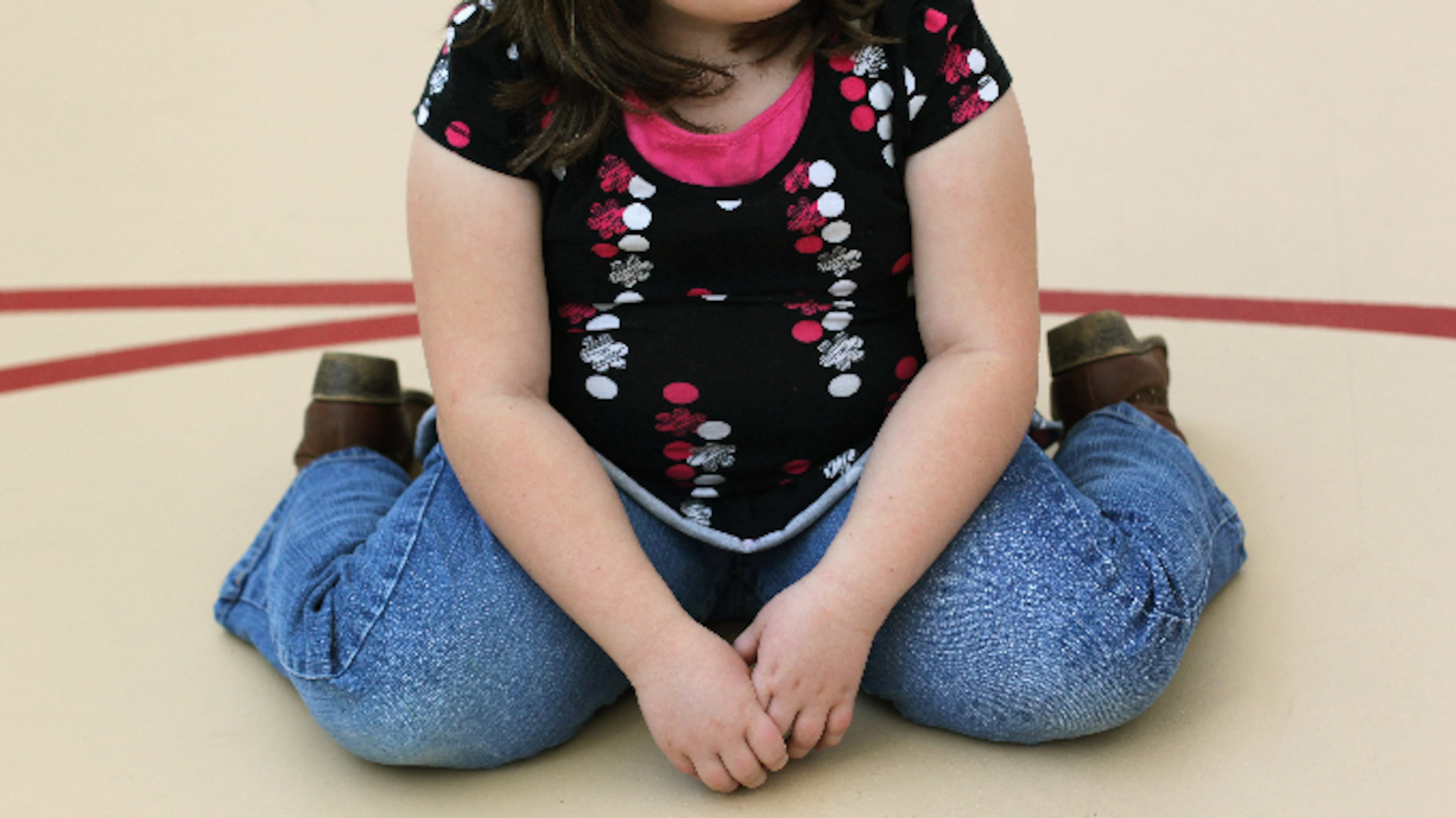 A child sits on the gym floor during the Shapedown program for overweight adolescents and children on November 13, 2010 in Aurora, Colorado.