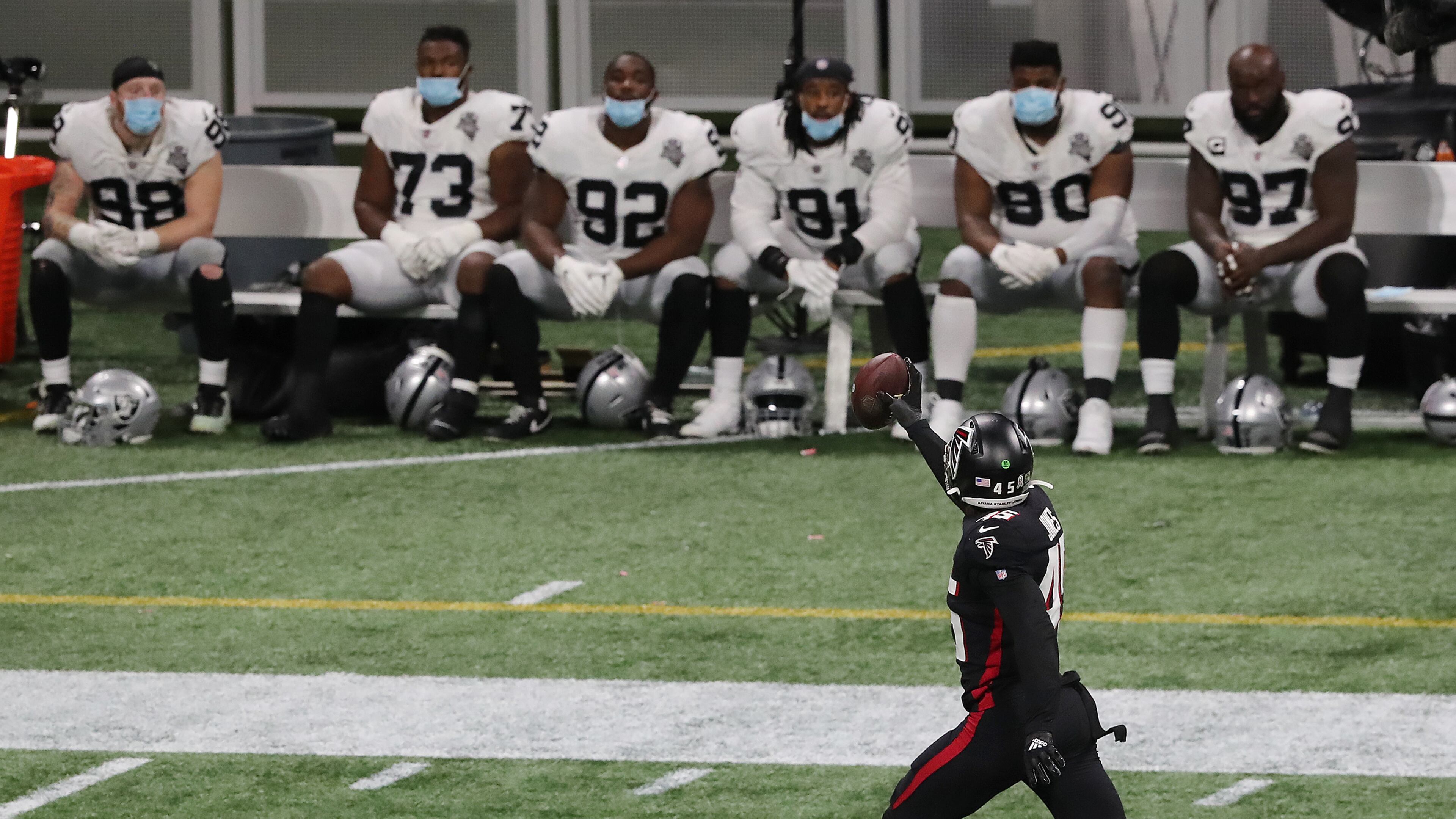 The Raiders bench looks on as Falcons linebacker Deion Jones intercepts a Derek Carr pass and returns it for a touchdown. (Curtis Compton / Curtis.Compton@ajc.com)
