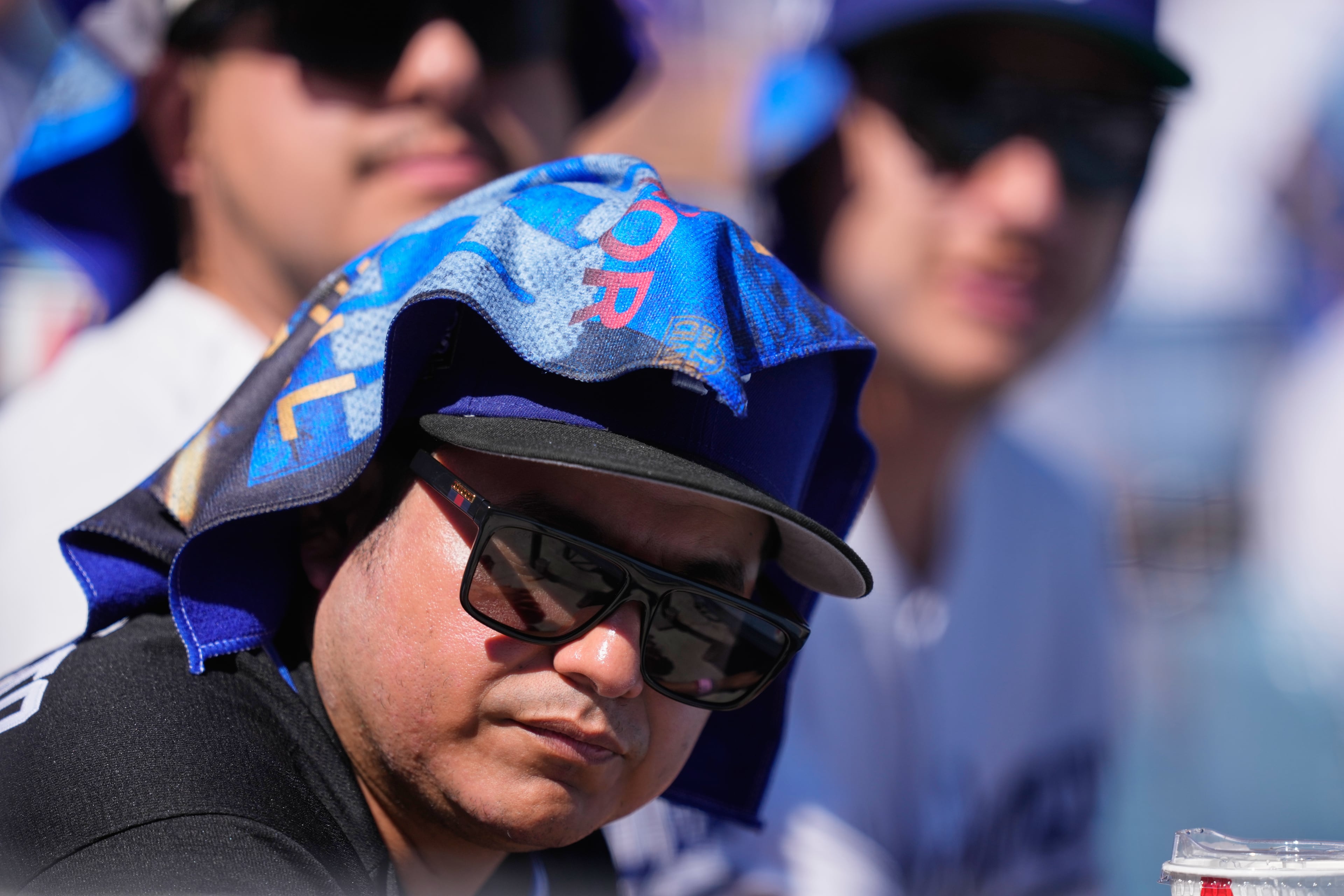Fans try to deal with the heat during the first inning of Game 1 of a National League Division Series baseball game between the Los Angeles Dodgers and the Atlanta Braves Saturday, Oct. 3, 2026, in Los Angeles. (Mark J. Terrill/AP)