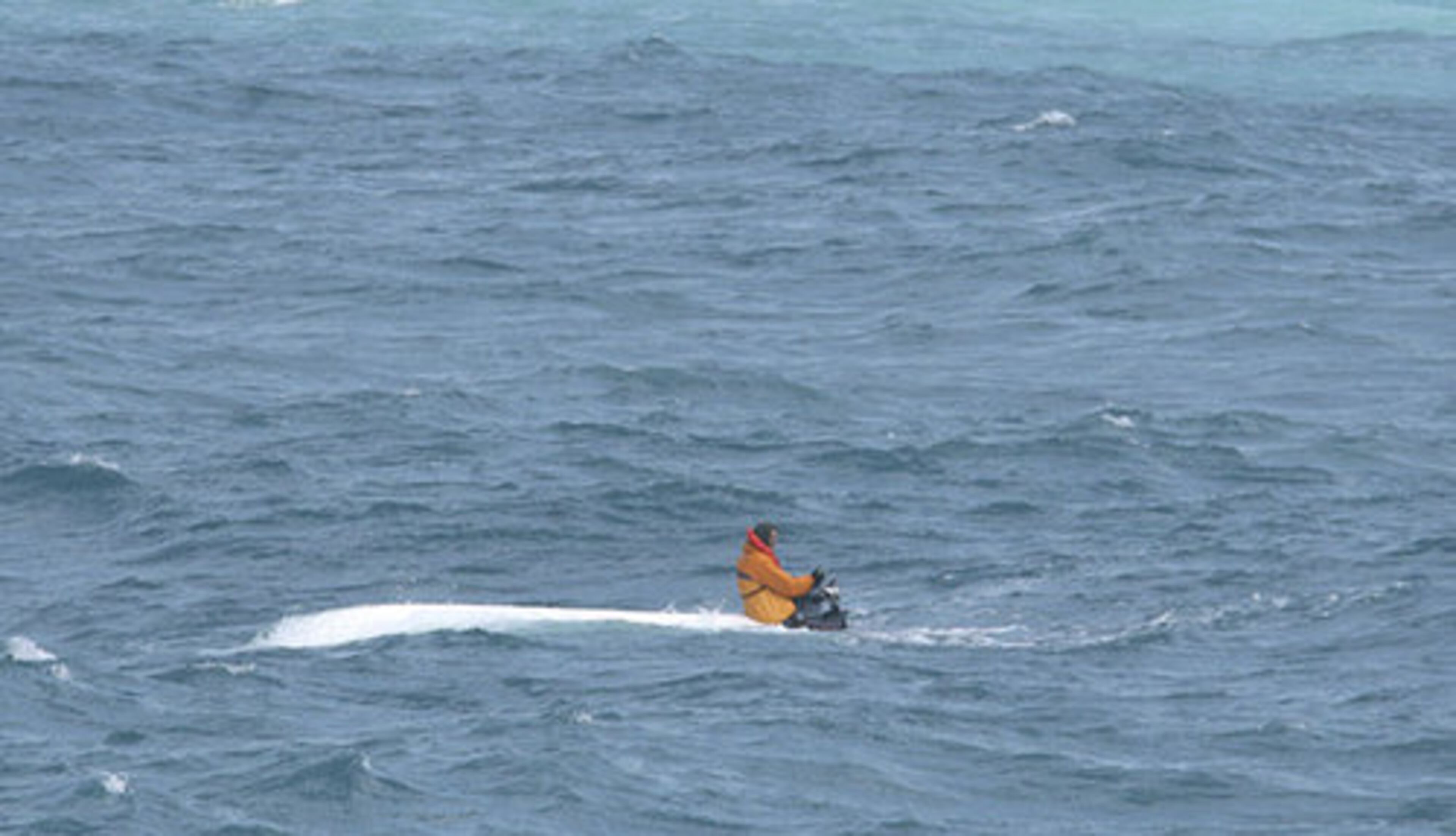 This photo released by the U.S. Coast Guard, shows Schuyler clinging to the engine of the overturned boat.