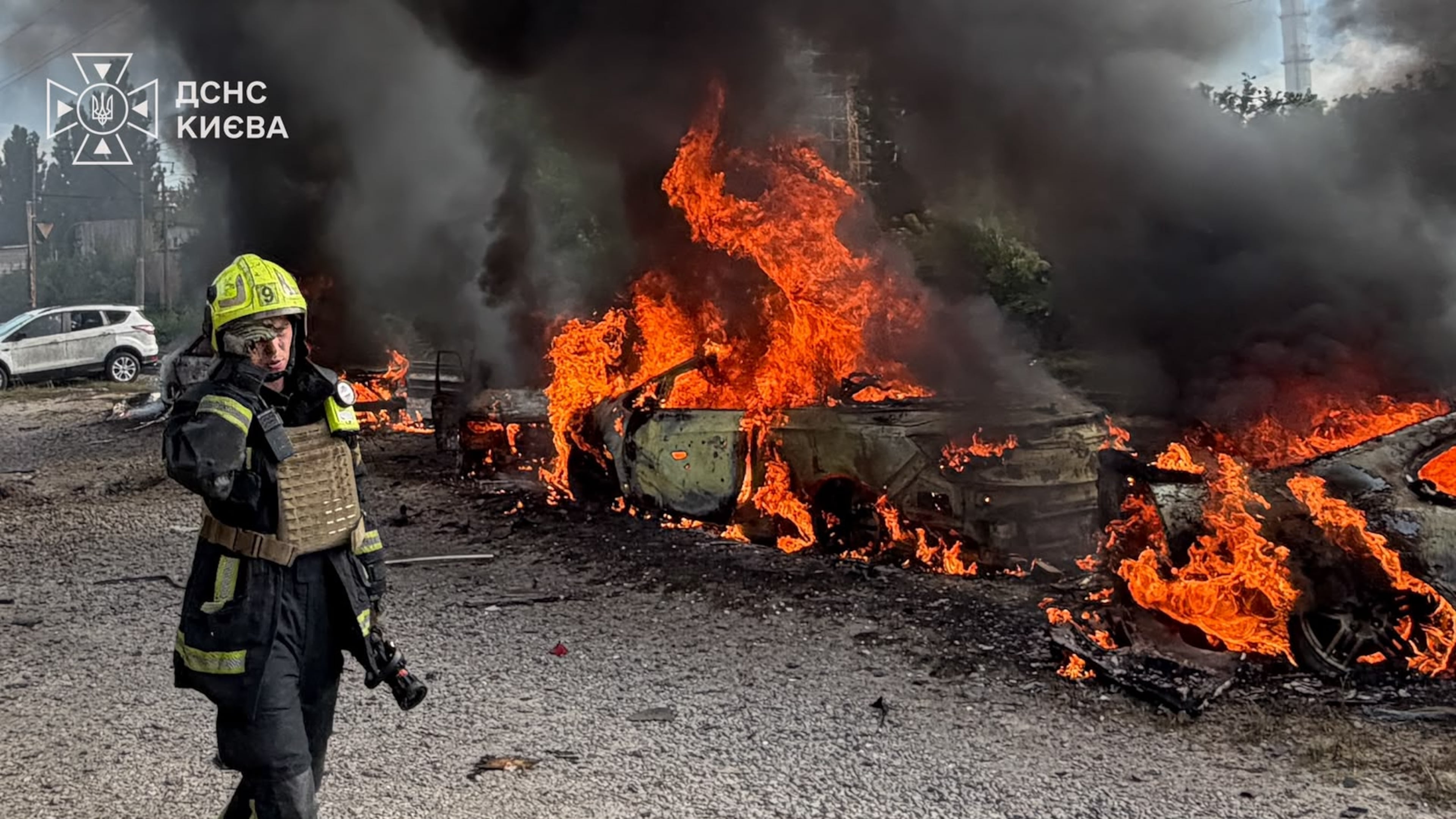 In this photo provided by the Ukrainian Emergency Service, a firefighters walk past burning cars as they work at the site, following a Russian air attack in Kyiv, Ukraine, Wednesday, Sept. 16, 2026. (Ukrainian Emergency Service via AP)