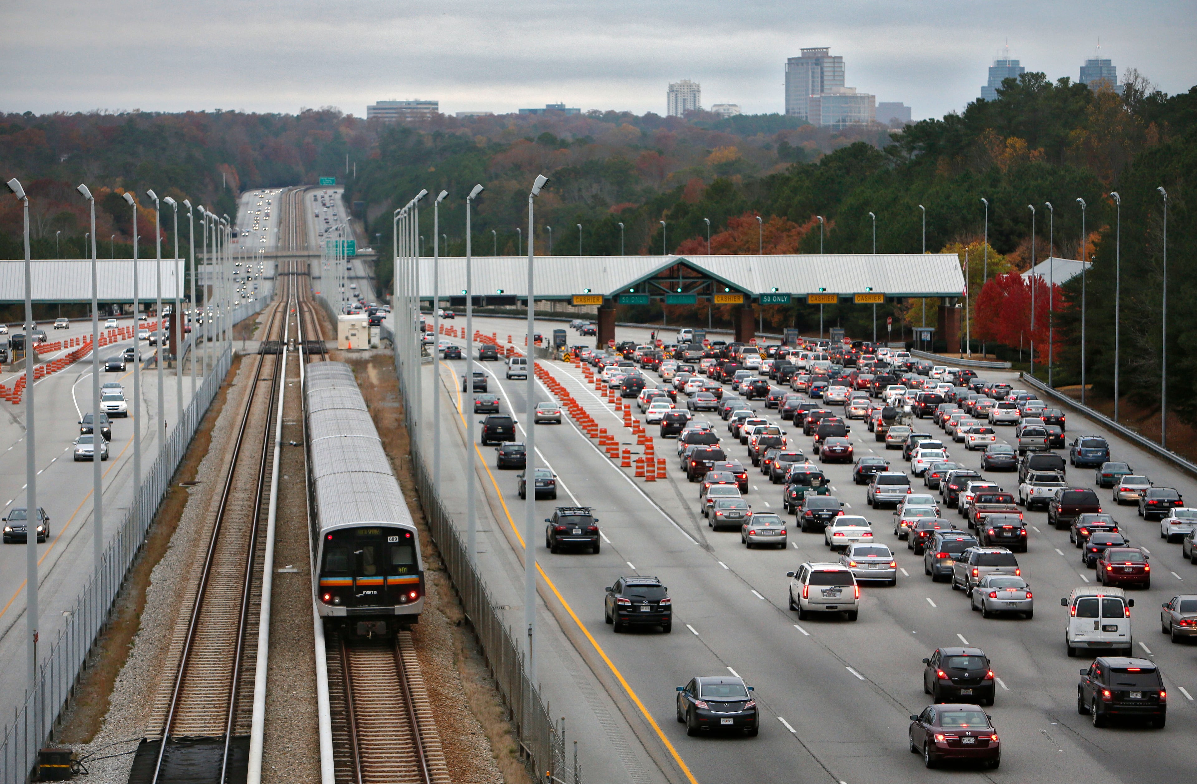 The toll booth signs have been taken down, and soon the toll booths will be gone. Morning commute traffic on GA 400 in the toll booth area. GA 400 tolls will end Nov. 22. BOB ANDRES / BANDRES@AJC.COM