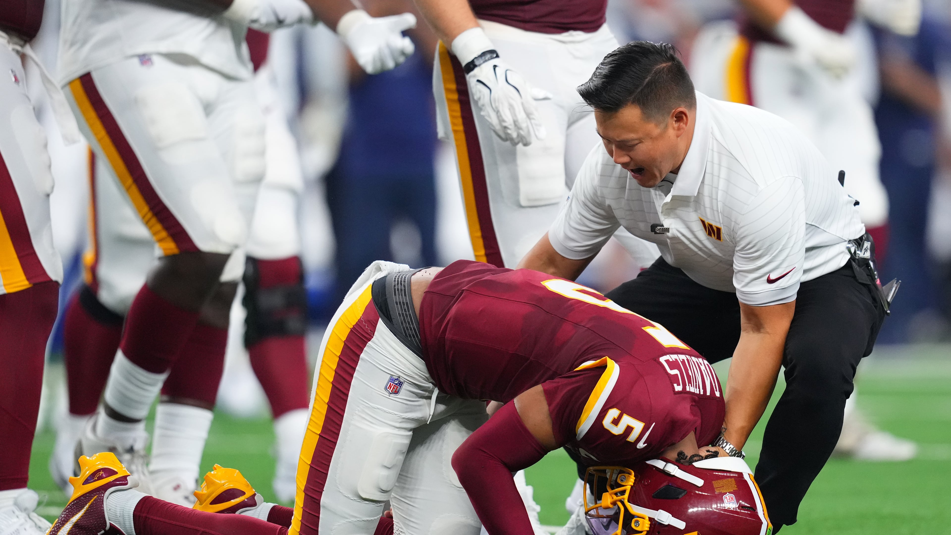 Washington Commanders quarterback Jayden Daniels (5) reacts after an apparent injury in the first half against the Dallas Cowboys during an NFL football game in Arlington, Texas, Sunday, Sept. 20, 2026. (AP Photo/Julio Cortez)