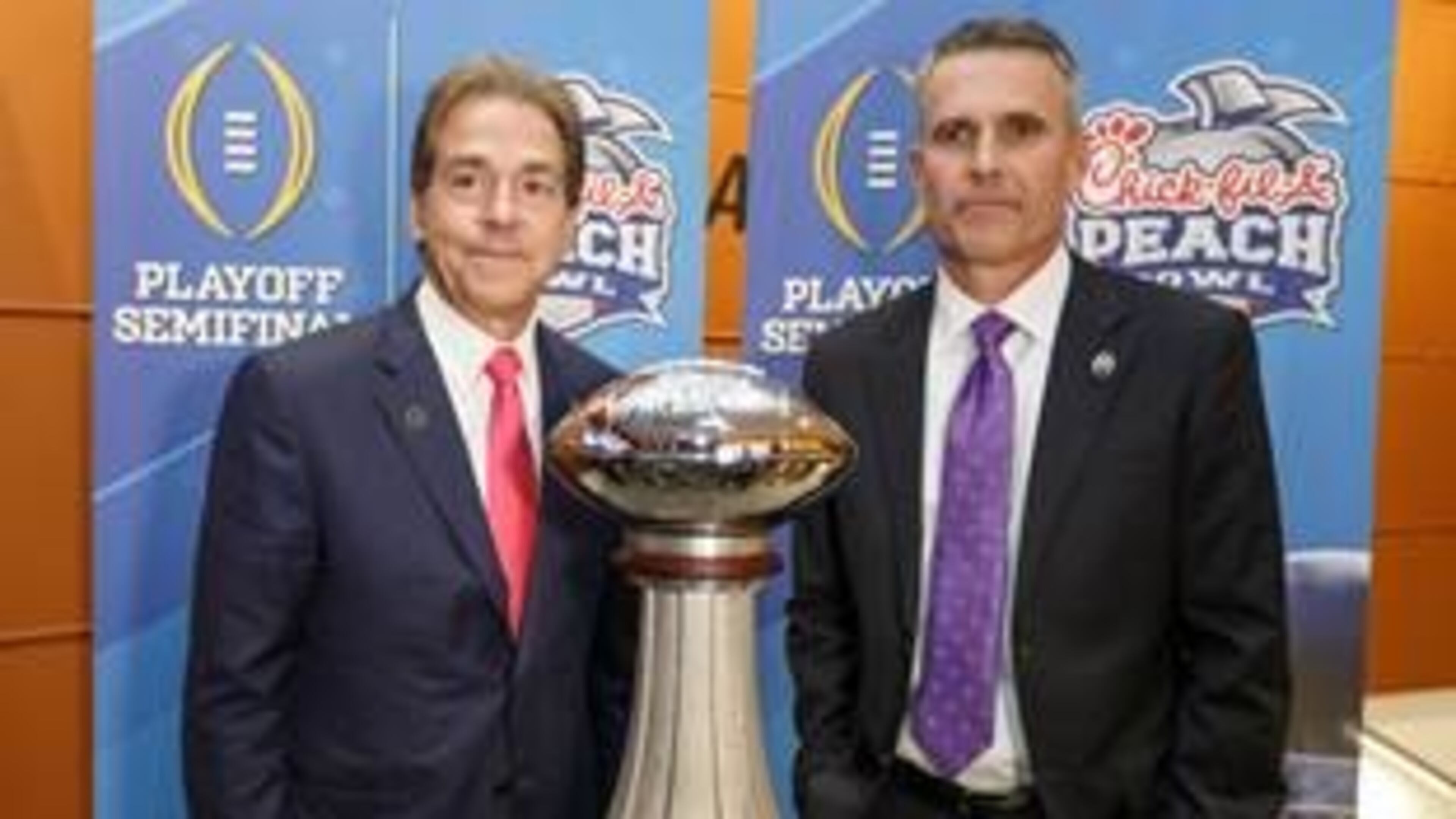 Alabama coach Nick Saban (left) and Washington coach Chris Petersen pose with the George P. Crumbley Trophy, which will be awarded to the winner of the Chick-fil-A Peach Bowl. (Special/Peach Bowl Inc.)
