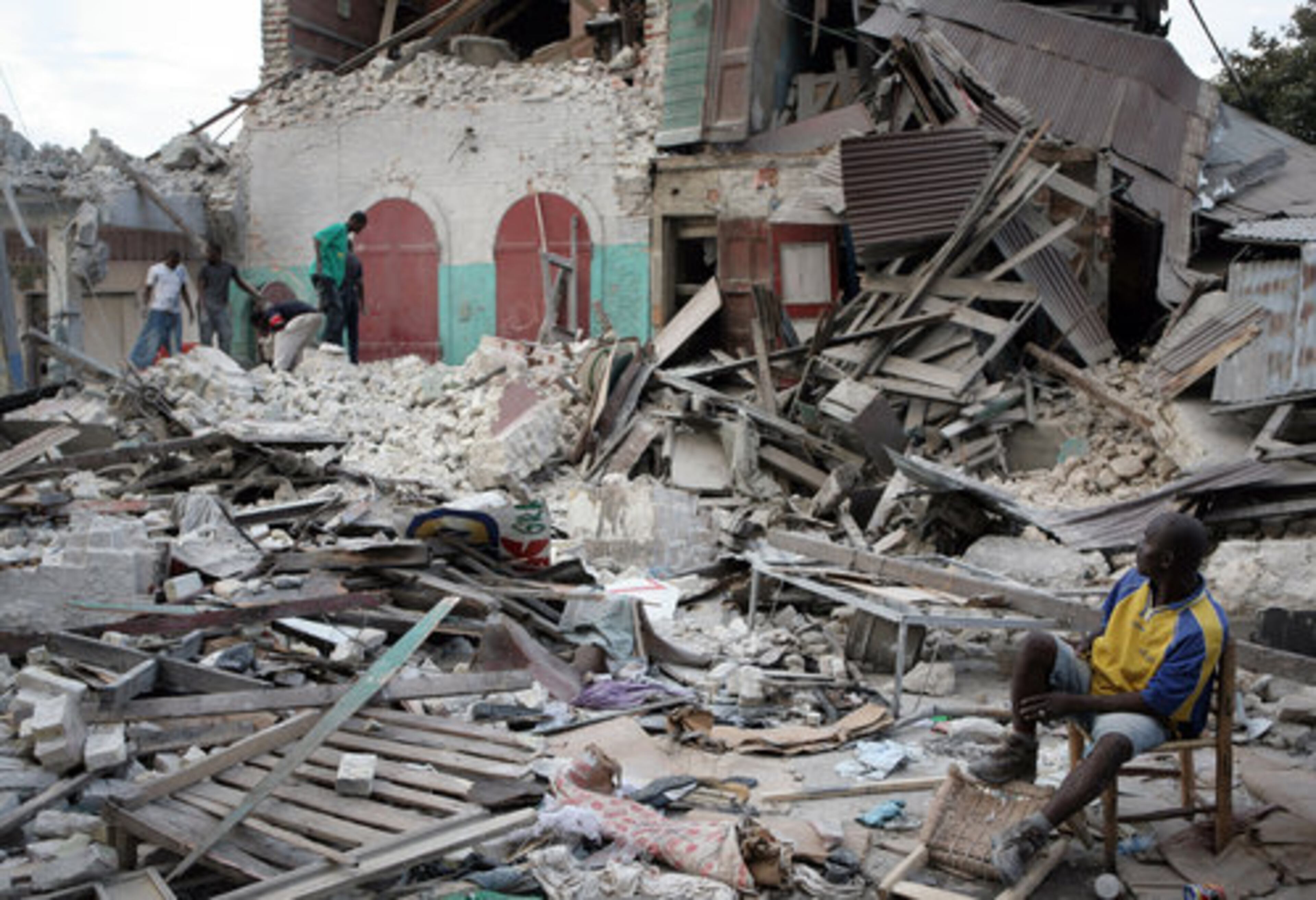 A man sits surrounded by rubble and debris in Port-au-Prince, Haiti, on Wednesday, Jan. 13, 2010. Huge swaths of Port-au-Prince lay in ruins, and thousands of people were feared dead in the rubble of government buildings, foreign aid headquarters and shantytowns that collapsed a day earlier in a powerful earthquake.