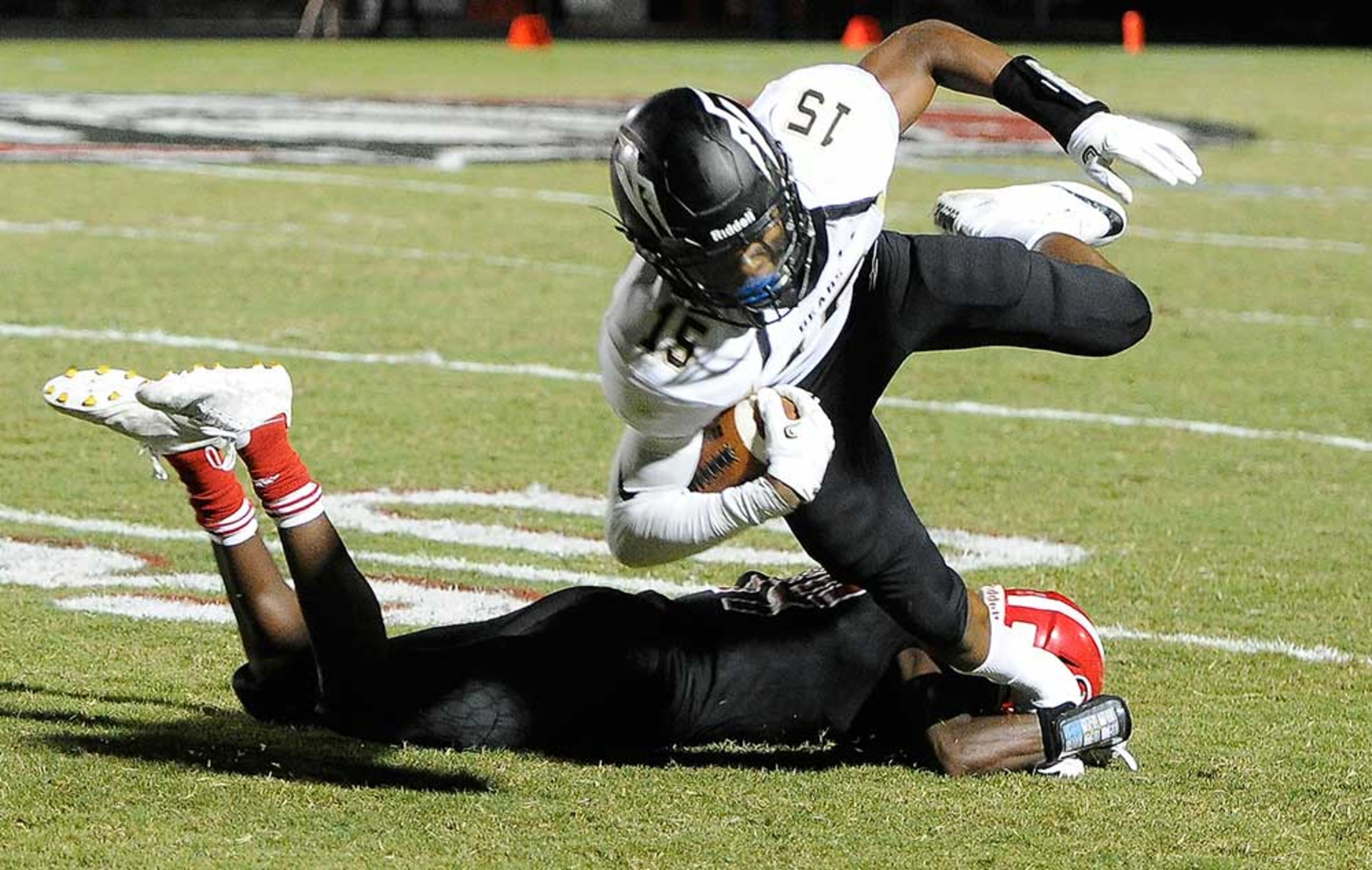 Mountain View WR Malachi Carter (15) gets tripped up by North Gwinnett DE Dixon Yellott during the first half of Friday's game.