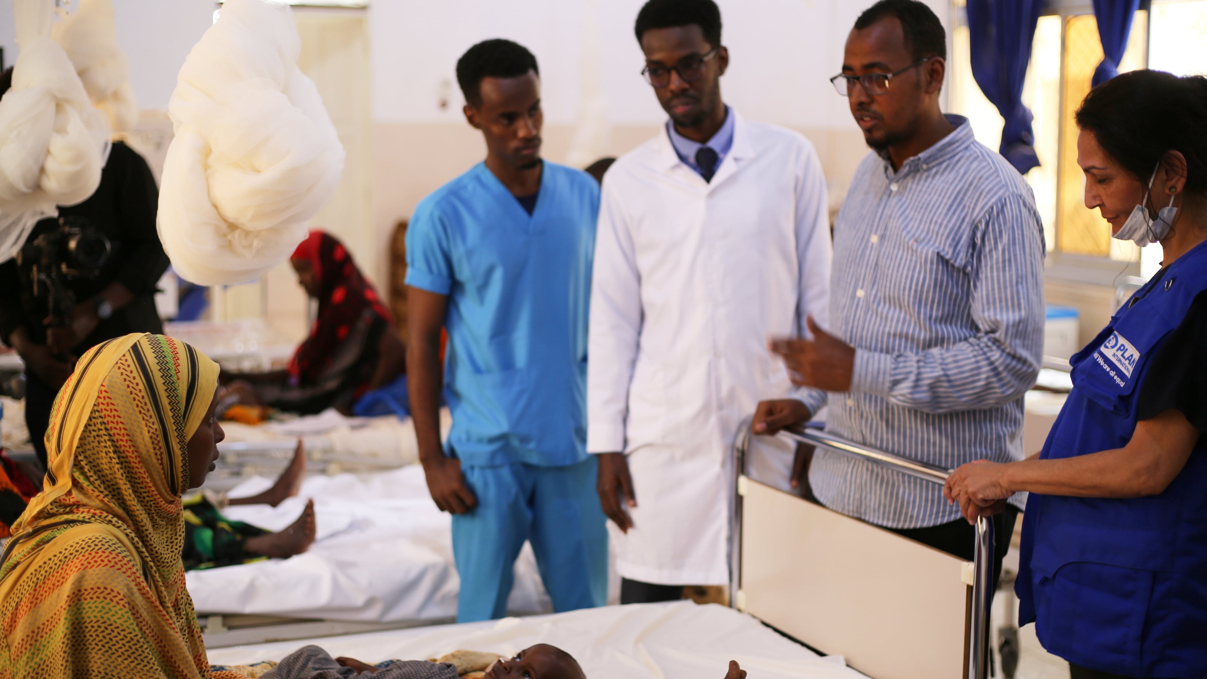 Health workers talk to a woman with her malnourished baby at Bay Hospital in Baidoa, Somalia, Tuesday, Aug. 4, 2026. (AP Photo/Mohamed Sheikh Nor)