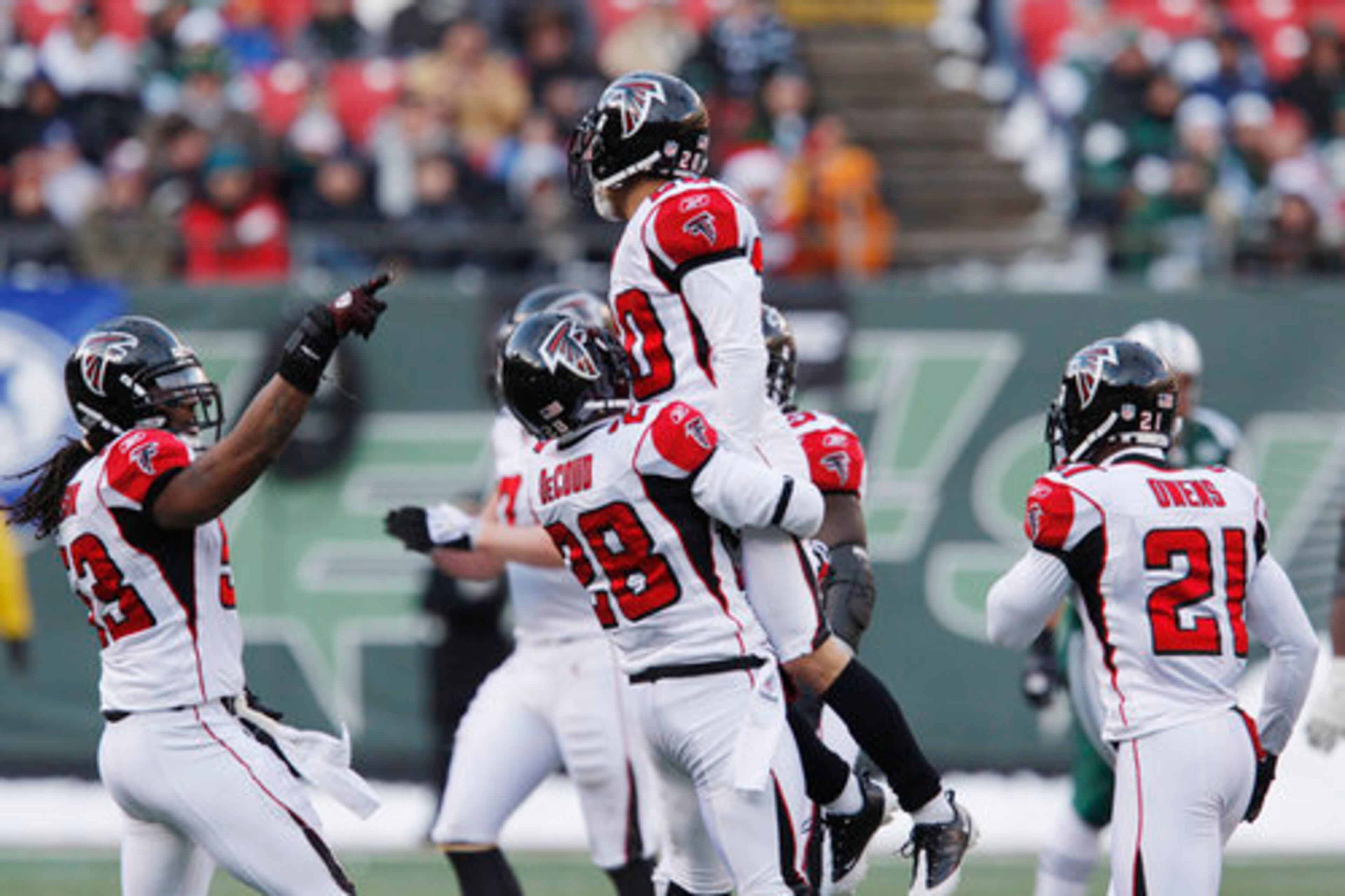 Falcons' Thomas DeCoud (28) lifts up Brent Grimes after Grimes intercepted a Mark Sanchez pass during the second quarter.