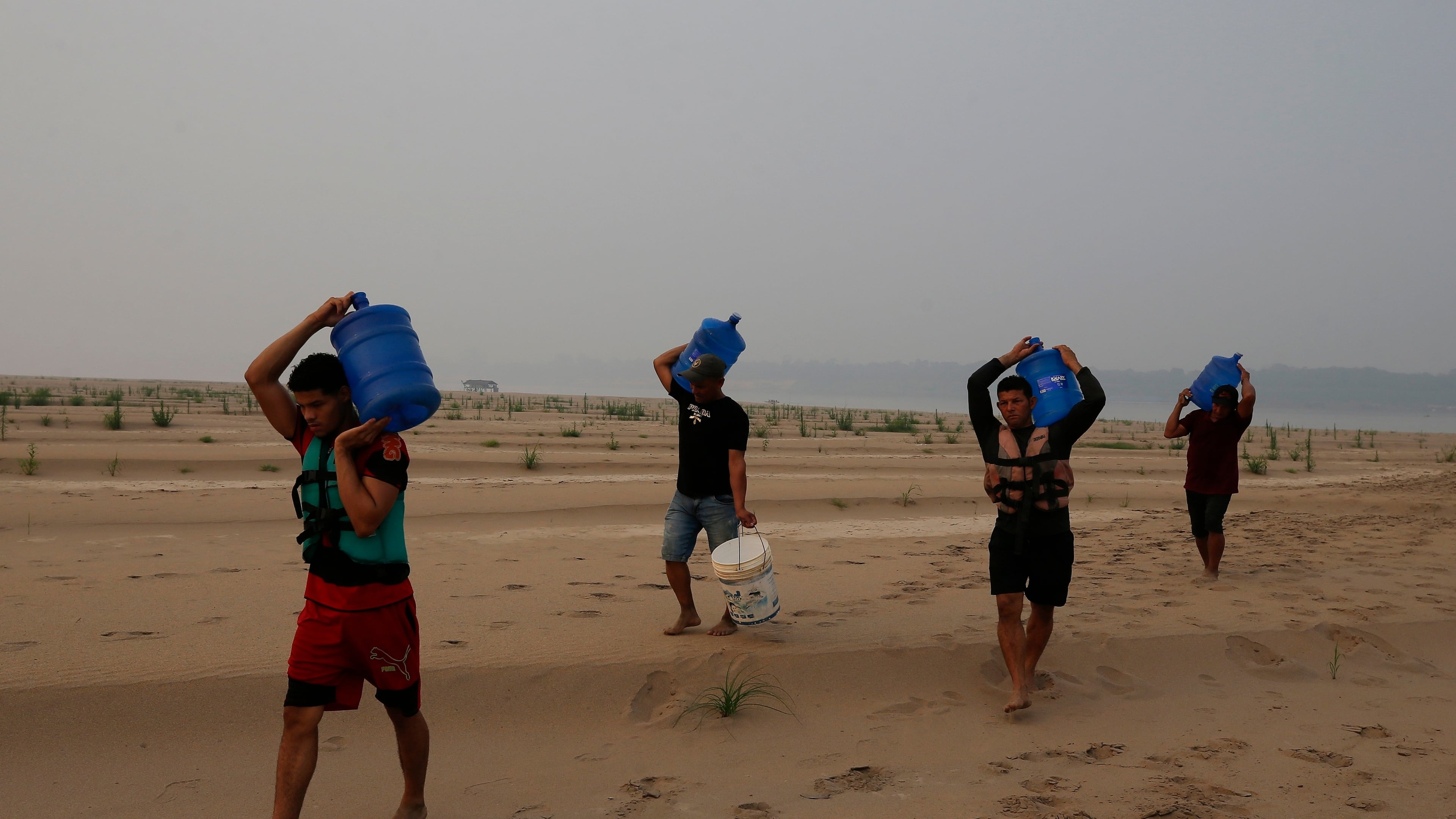 FILE - Residents transport drinking water from Humaita to the Paraizinho community, along a dry part of the Madeira River, a tributary of the Amazon River, amid a drought, Amazonas state, Brazil, Sep. 8, 2024. (AP Photo/Edmar Barros, File)