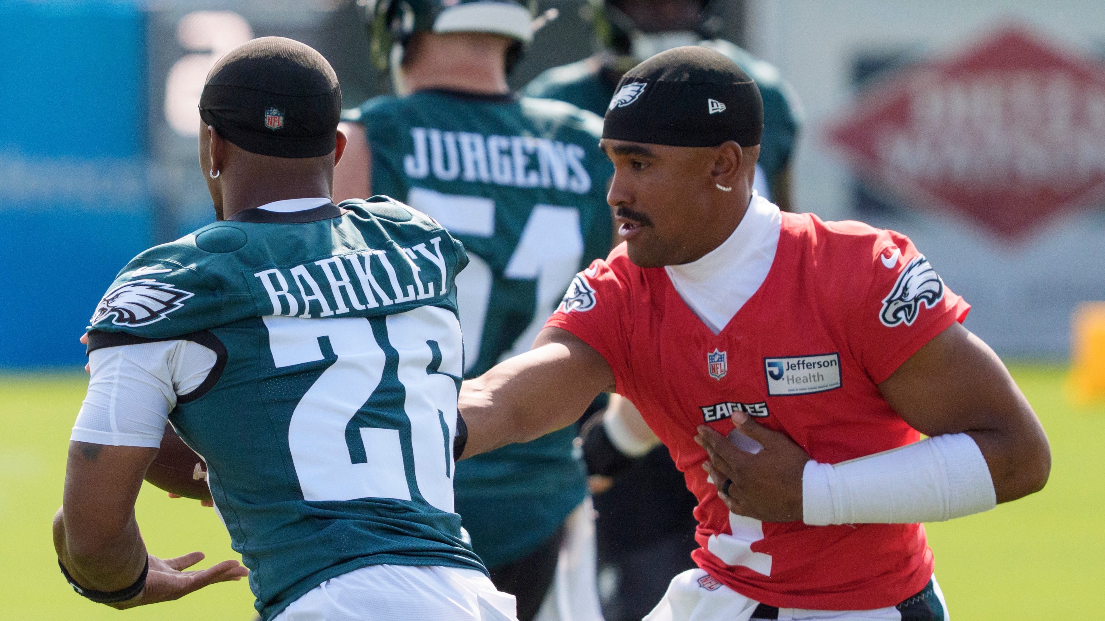 Philadelphia Eagles quarterback Jalen Hurts (1) hands the ball off to running back Saquon Barkley (26) during practice at the team's NFL football training camp in Philadelphia, Wednesday, July 29, 2026. (AP Photo/Chris Szagola)