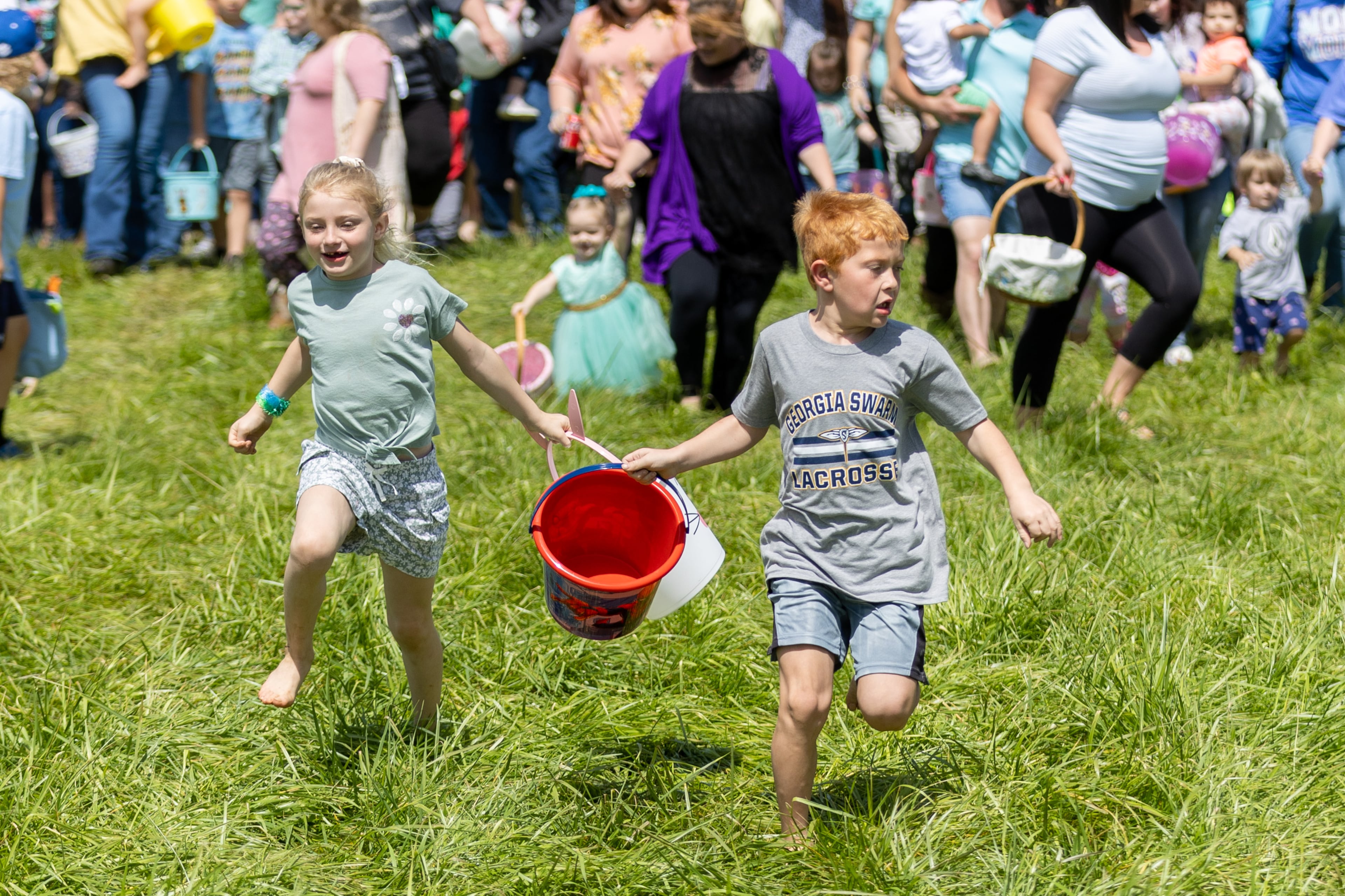 Naveah Thompson and her cousin Ben Shook head out looking for eggs at the start of the Homer Easter Egg Hunt “In Celebration of Mack Garrison” in Homer on Saturday, April 1, 2023. (Steve Schaefer/steve.schaefer@ajc.com)