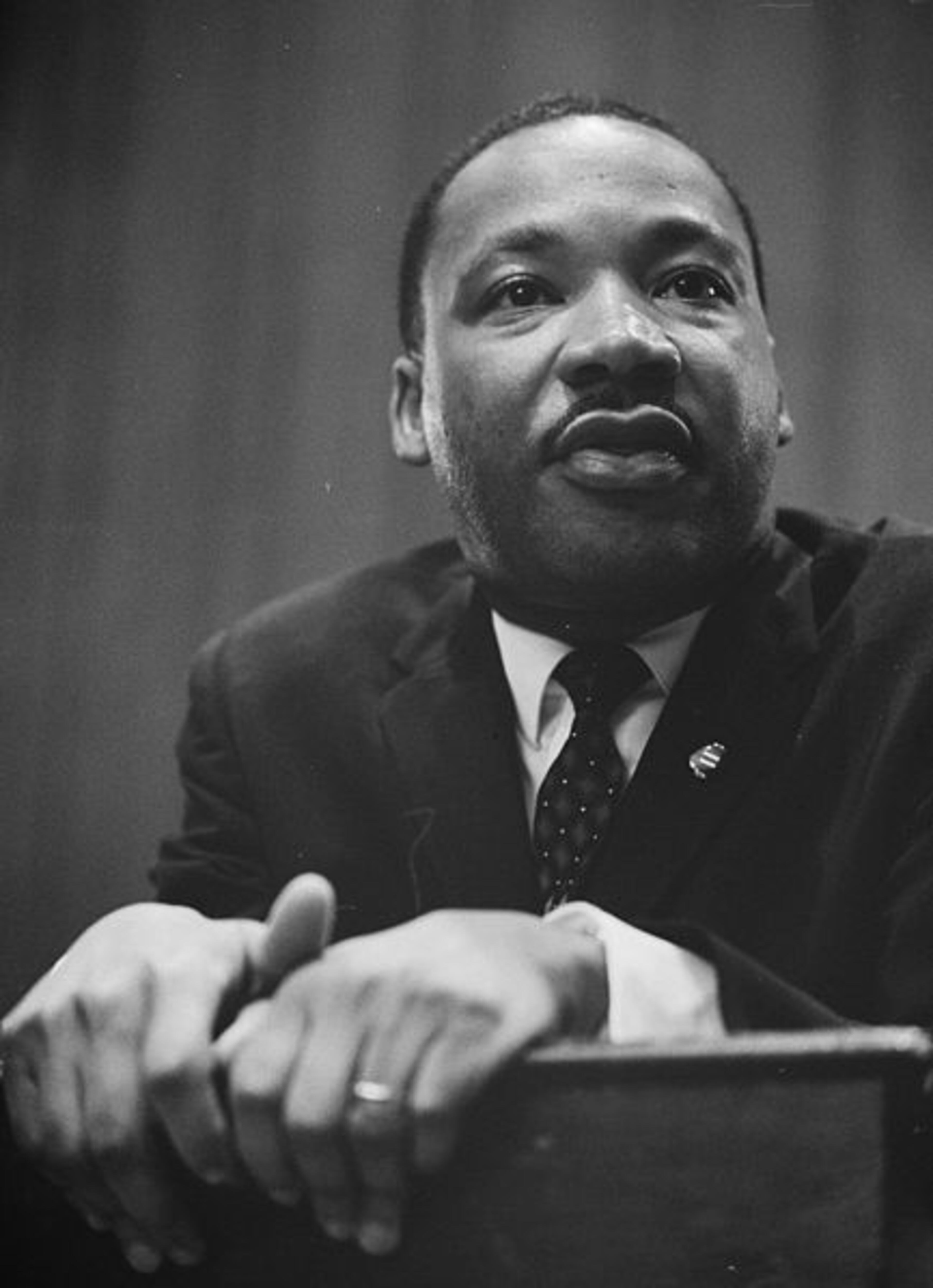 Martin Luther King Jr. leaning on a lectern.