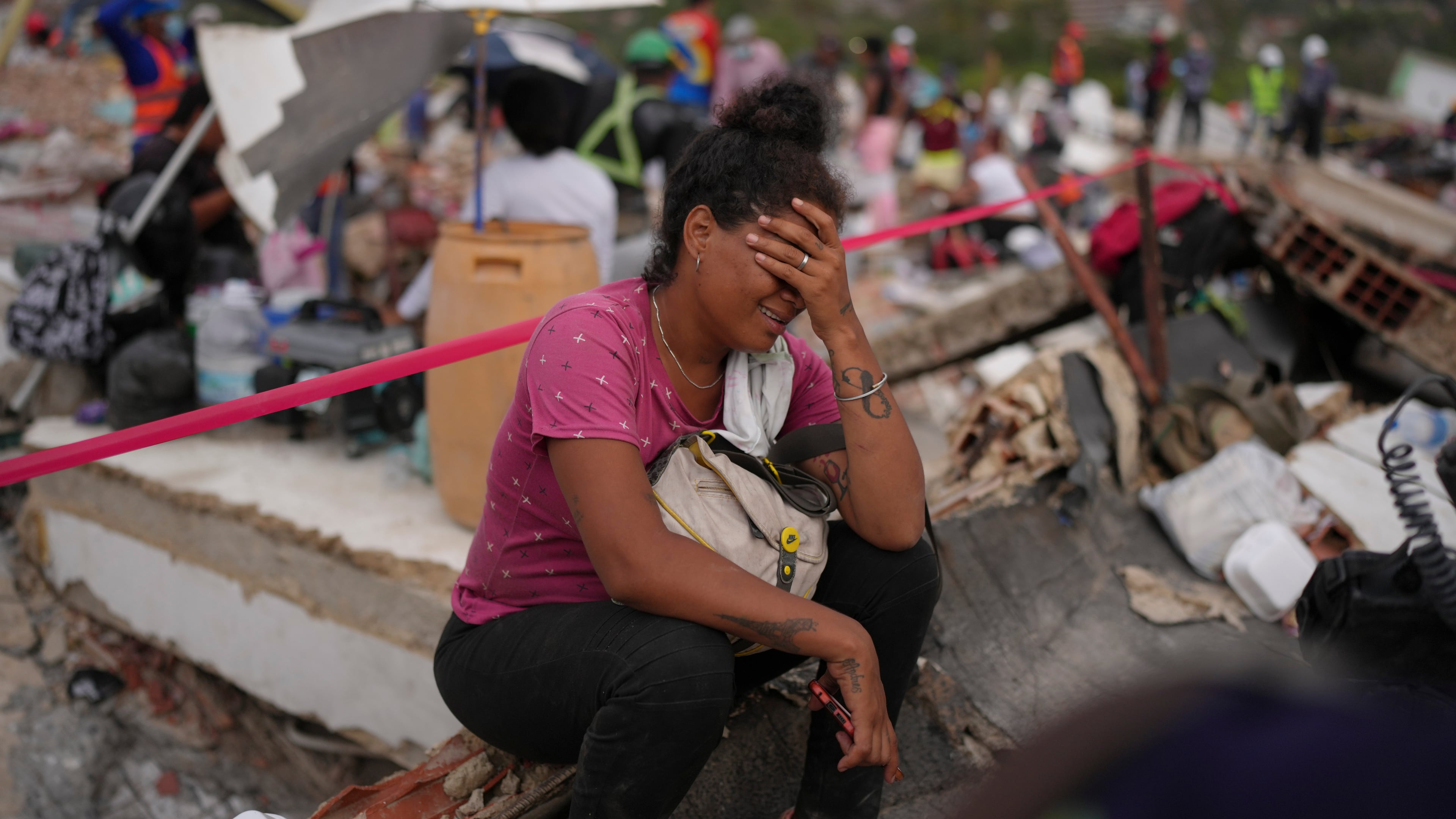Khaterine Roa cries as members of the Los Angeles County Fire Department search for survivors at a building that collapsed during the earthquakes that struck La Guaira, Venezuela, Tuesday, June 30, 2026. (AP Photo/Matias Delacroix)
